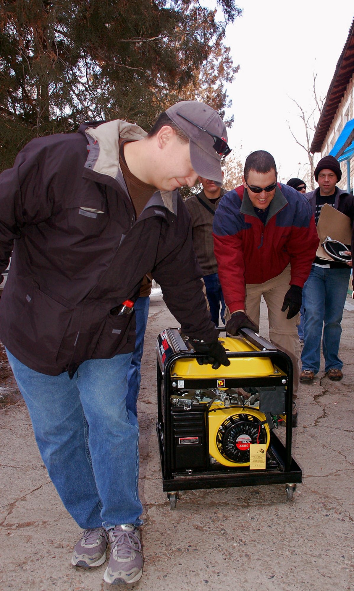 Maj. Shane Noyes and Master Sgt. John Pahukoa deliver a new generator Feb. 20 to the Vasilievka Kindergarten School in Kyrgyzstan. Along with the new generator, volunteer Airmen recently donated a new refrigerator and stove to the school as well through donations raised by the Manas Service Organization. Major Noyes is chief of the 376th Air Expeditionary Wing Plans and Programs Office deployed from Scott Air Force Base, Ill. Sergeant Pahukoa is assigned to the 376th Expeditionary Civil Engineer Squadron deployed from Hurlburt Field, Fla. (U.S. Air Force photo/Tech. Sgt. Phyllis Hanson) 
