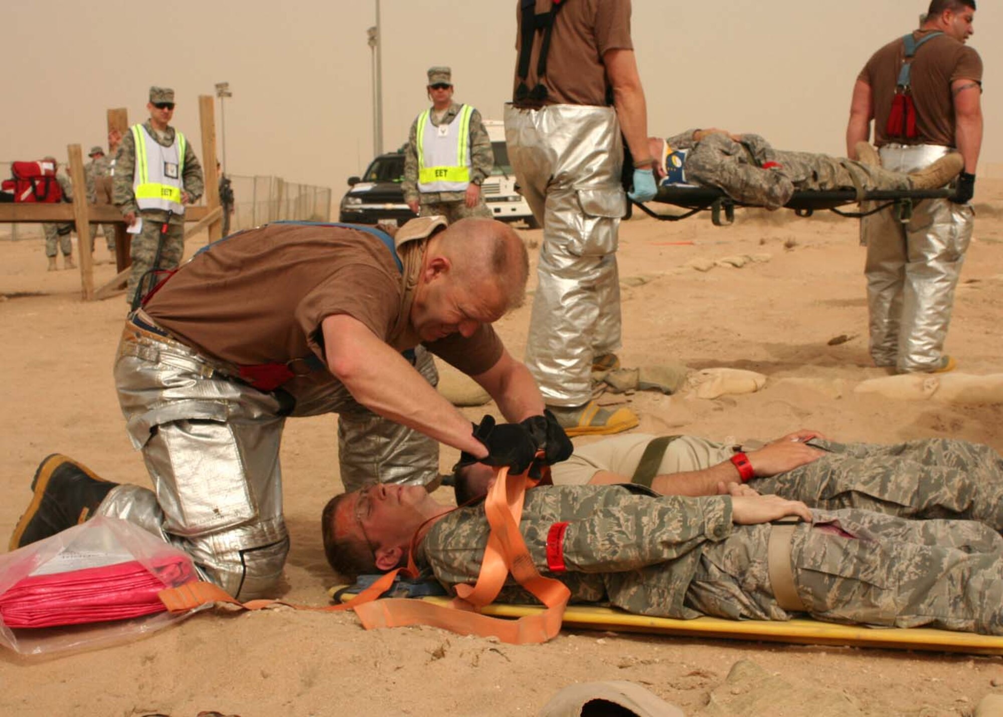 SOUTHWEST ASIA -- Tech. Sgt. Craig Moore, 386th Expeditionary Civil Engineering Squadron, buckles down a mock victim for transport to the clinic during an exercise at an air base in Southwest Asia, Feb. 23. The exercise was an evaluation of multi- agency response to a mass casualty incident to include Security Forces, Fire Department and Medical teams. (U.S. Air Force photo/ Staff Sgt. Shaun Denton)