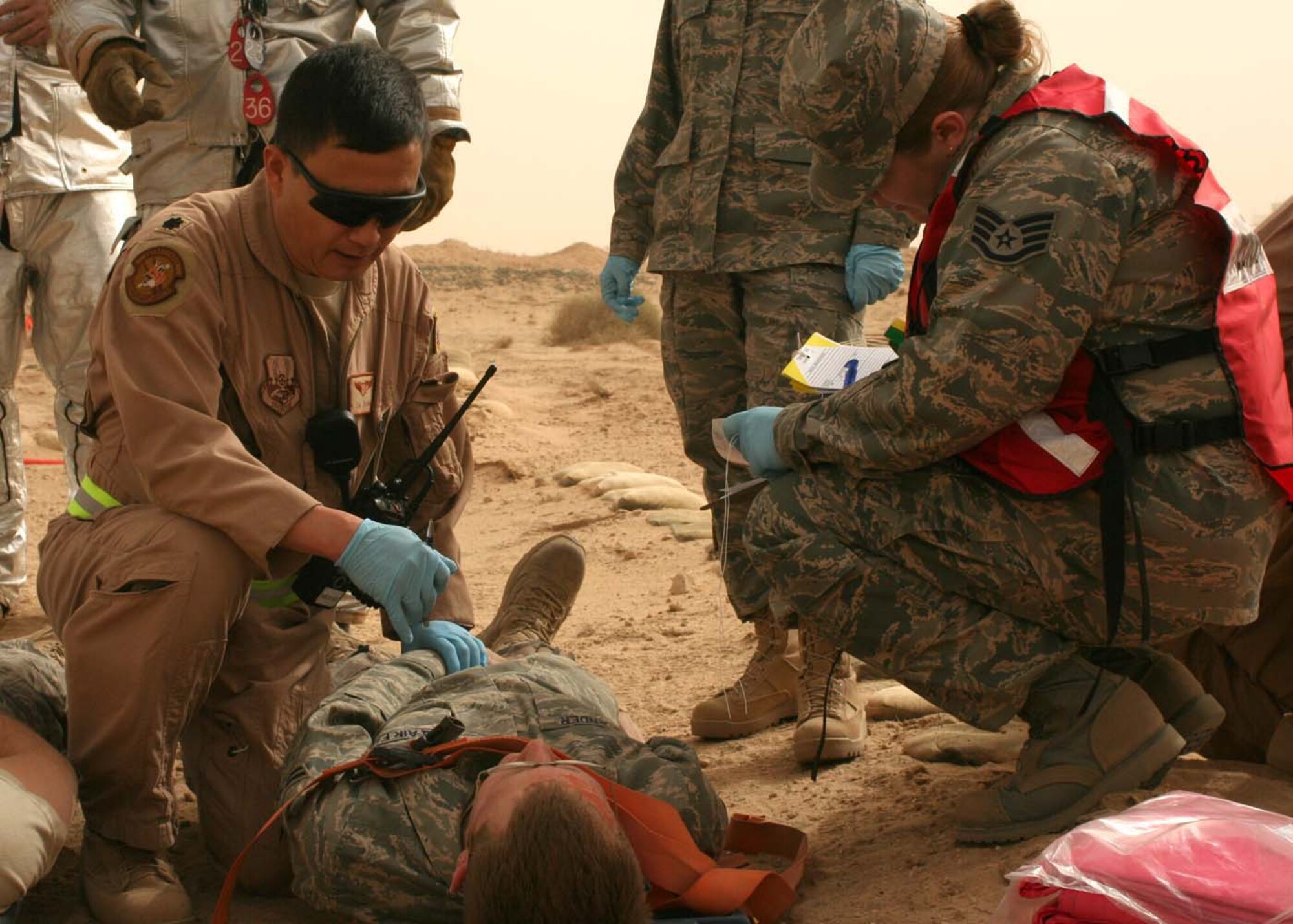 SOUTHWEST ASIA -- Lt. Col. Jianzhong Zhang, 386th Air Expeditionary Medical Group, evaluates a mock victim while Staff Sgt. Betty Schnoop, 386th EMDG, transcribes during an exercise at an air base in Southwest Asia, Feb. 23. The exercise required the response of Security Forces, Fire Department, and Medical teams to a bus accident. (U.S. Air Force photo/ Staff Sgt. Shaun Denton)