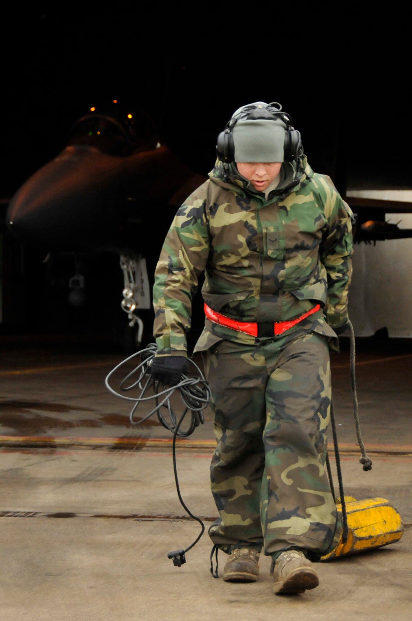 Airman 1st Class James Forrest, 48th Aircraft Maintenance Squadron F-15 crew chief, pulls the tire chocks out of the protective aircraft shelter Feb. 11, 2009, at RAF Lakenheath, England. The F-15 will taxi outside the protective aircraft shelter to finish its pre-flight inspection. (U.S. Air Force photo by Airman 1st Class Perry Aston) 