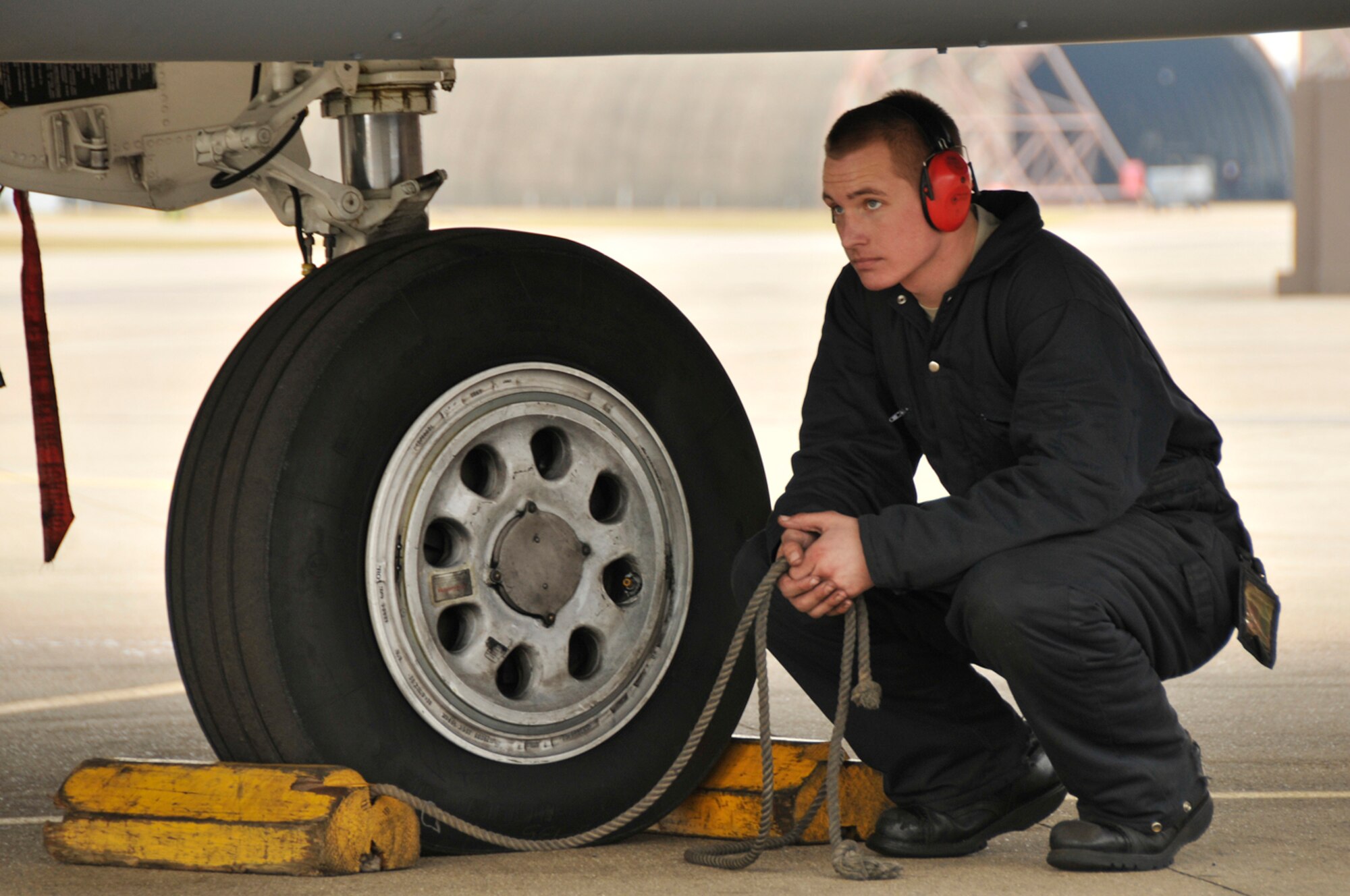 Airman 1st Class Jason Anderson and Senior Airman Charles White, 48th Aircraft Maintenance Squadron F-15 crew chiefs, prepare to un-chock the tires of an F-15 Strike Eagle Feb. 11, 2009, at RAF Lakenheath, England. Wheel chocks ensure the aircraft doesn't move while the crew chiefs perform a final pre-flight inspection. (U.S. Air Force photo by Airman 1st Class Perry Aston) 