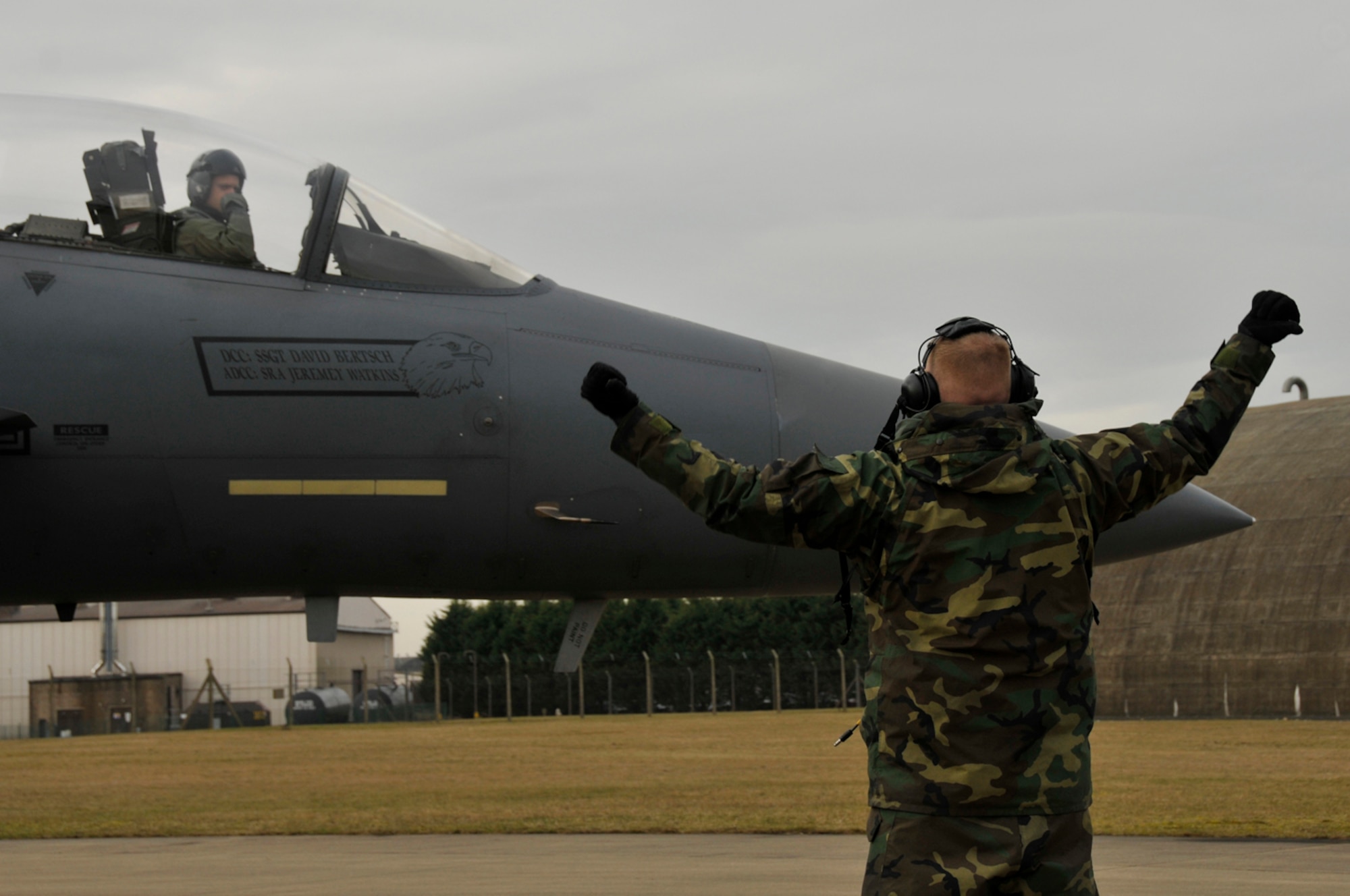 Airman 1st Class Justin Lloyd, 48th Aircraft Maintenance Squadron F-15 crew chief, signals Capt. Bradley Brandt, 494th Fighter Squadron pilot, that the wheel chocks have been pulled out Feb. 11, 2009, at RAF Lakenheath, England  (U.S. Air Force photo by Airman 1st Class Perry Aston)