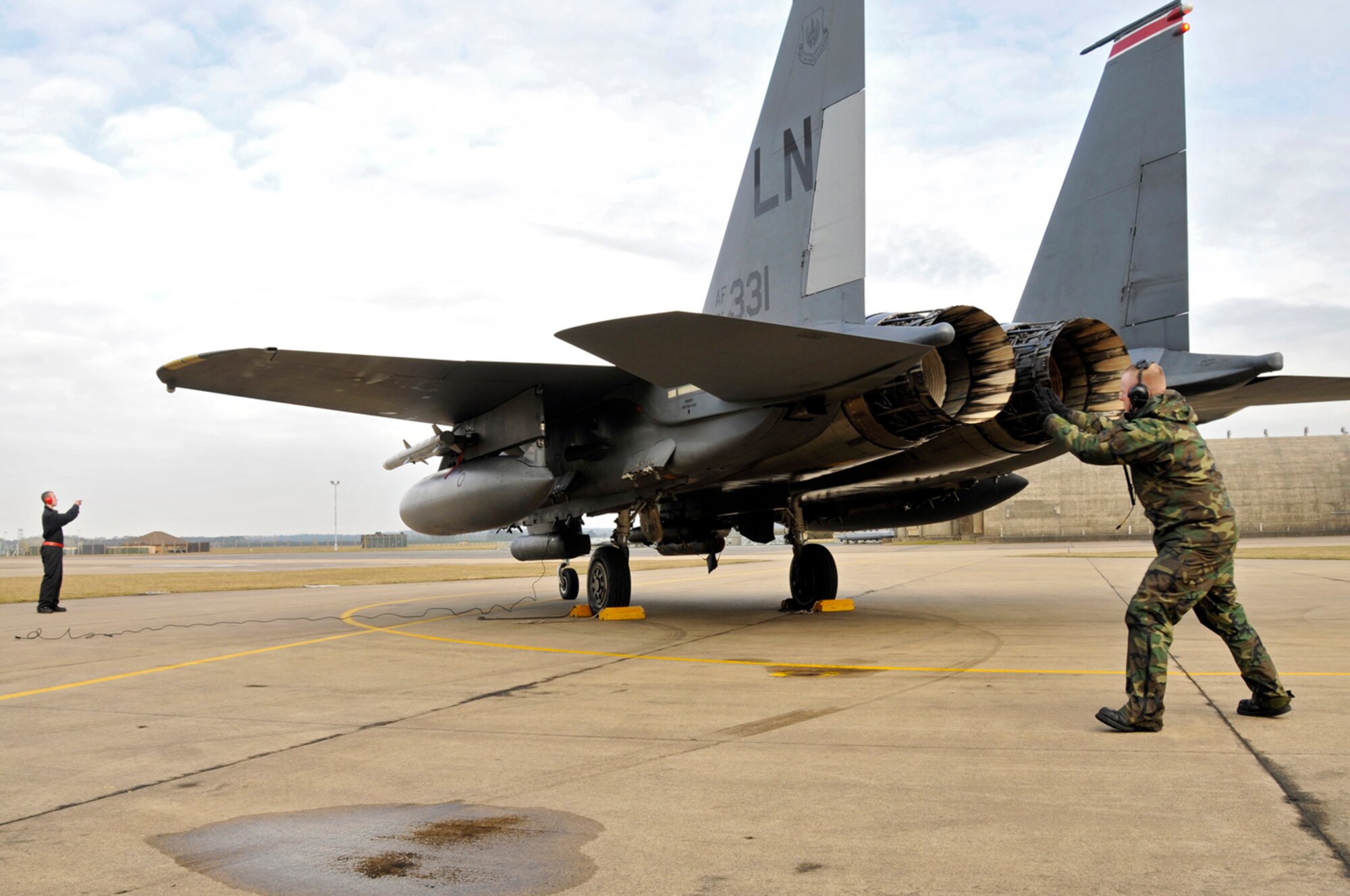 Airman 1st Class Dominic Dizes, 48th Aircraft Maintenance Squadron F-15 crew chief, throws a wheel chock underneath one of the wheels of a F-15E Strike Eagle Feb. 11, 2009, at RAF Lakenheath, England. Wheel chocks will ensure the aircraft doesn't move while the crew chiefs perform a final pre-flight inspection. (U.S. Air Force photo by Airman 1st Class Perry Aston) 