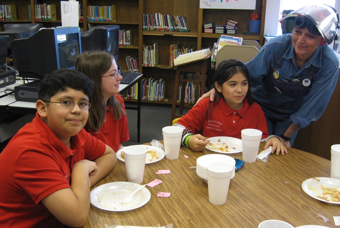 Rosie the Riveter, a mainstay of World War II, is depicted by Laverne Easter at
Sheppard Elementary's luncheon program for members of the 64th Annual Iwo
Jima Survivors Reunion, who visited the school 20 Feb. Pictured with "Rosie"
are Sheppard Elementary students Isaac Gonzalez, Samantha Pikell, and
Arianna Gonzales. (U.S. Air Force photo/Debi Smith)
