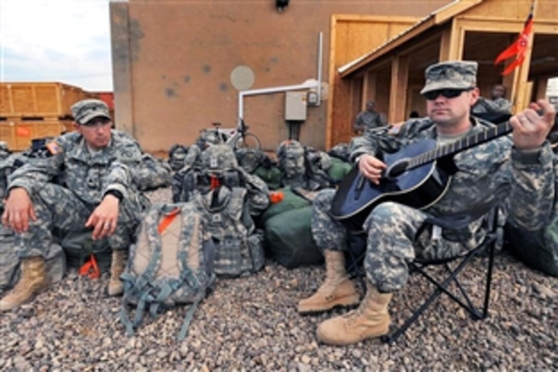U.S. Army soldiers relax while waiting to board a transit bus on Camp Taji, Iraq, Feb. 23, 2009. The soldiers, assigned to the 25th Infantry Division's 556th Signal Company, 2nd Stryker Brigade Combat Team, are re-deploying to Hawaii after spending the last 15 months in Iraq.