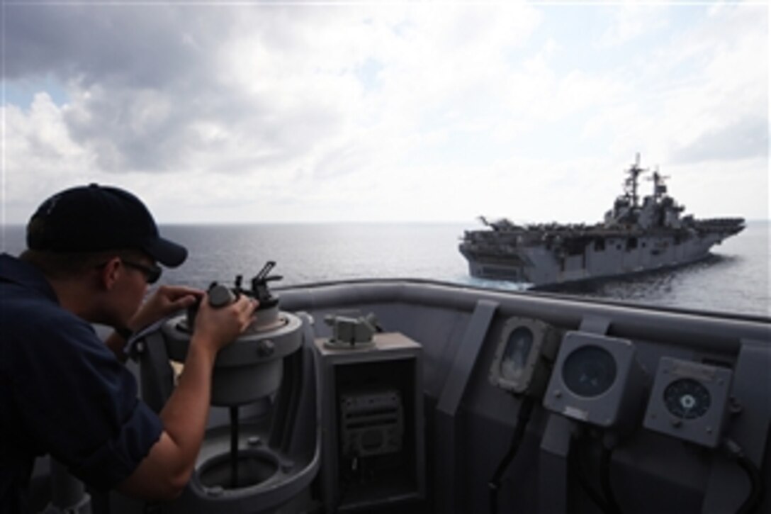 U.S. Navy Ensign Peter Larson uses an azimuth to find the heading to the amphibious assault ship USS Essex (LHD 2) from the landing dock ship USS Harpers Ferry (LSD 49) prior to a replenishment exercise with Essex in the Gulf of Thailand on Feb. 24, 2009.  The Harpers Ferry and Essex are forward deployed to Sasebo, Japan.  