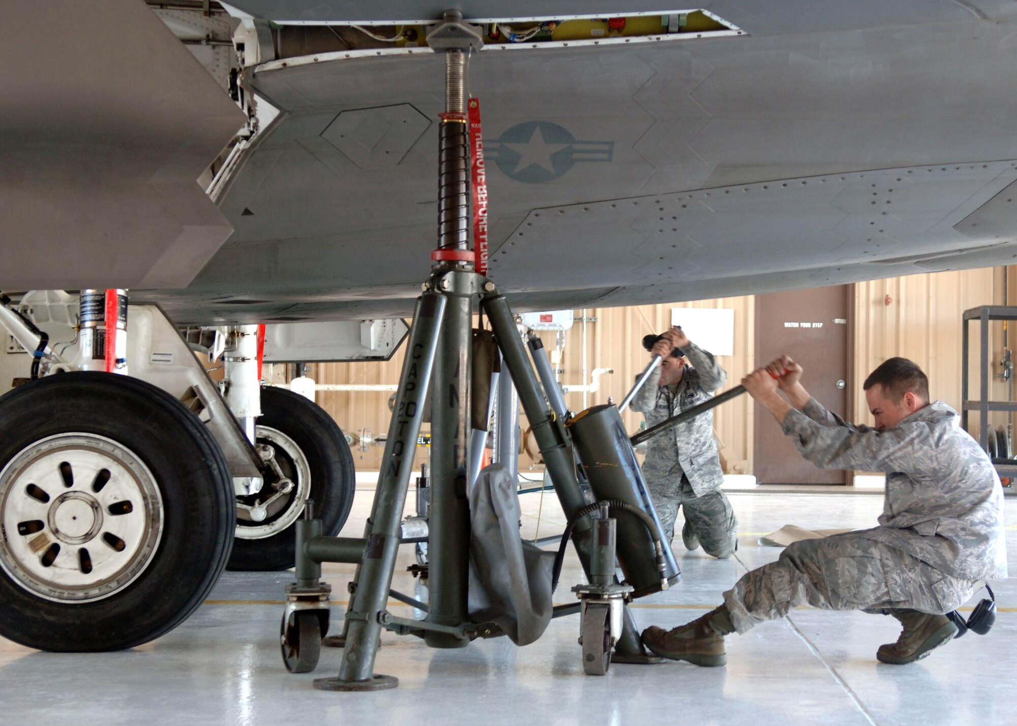 Senior Airman Mark Legar, 49th Aircraft Maintenance Squadron, jacks up an F-22A Raptor to check the main landing gear struts at Holloman Air Force Base, N.M., Feb. 25. Crew members of the 49 AMXS use aircraft jacks to inspect the struts for safe landing as part of prep generation for aircraft deployment. (U.S. Air Force photo/Airman 1st Class Veronica Salgado)