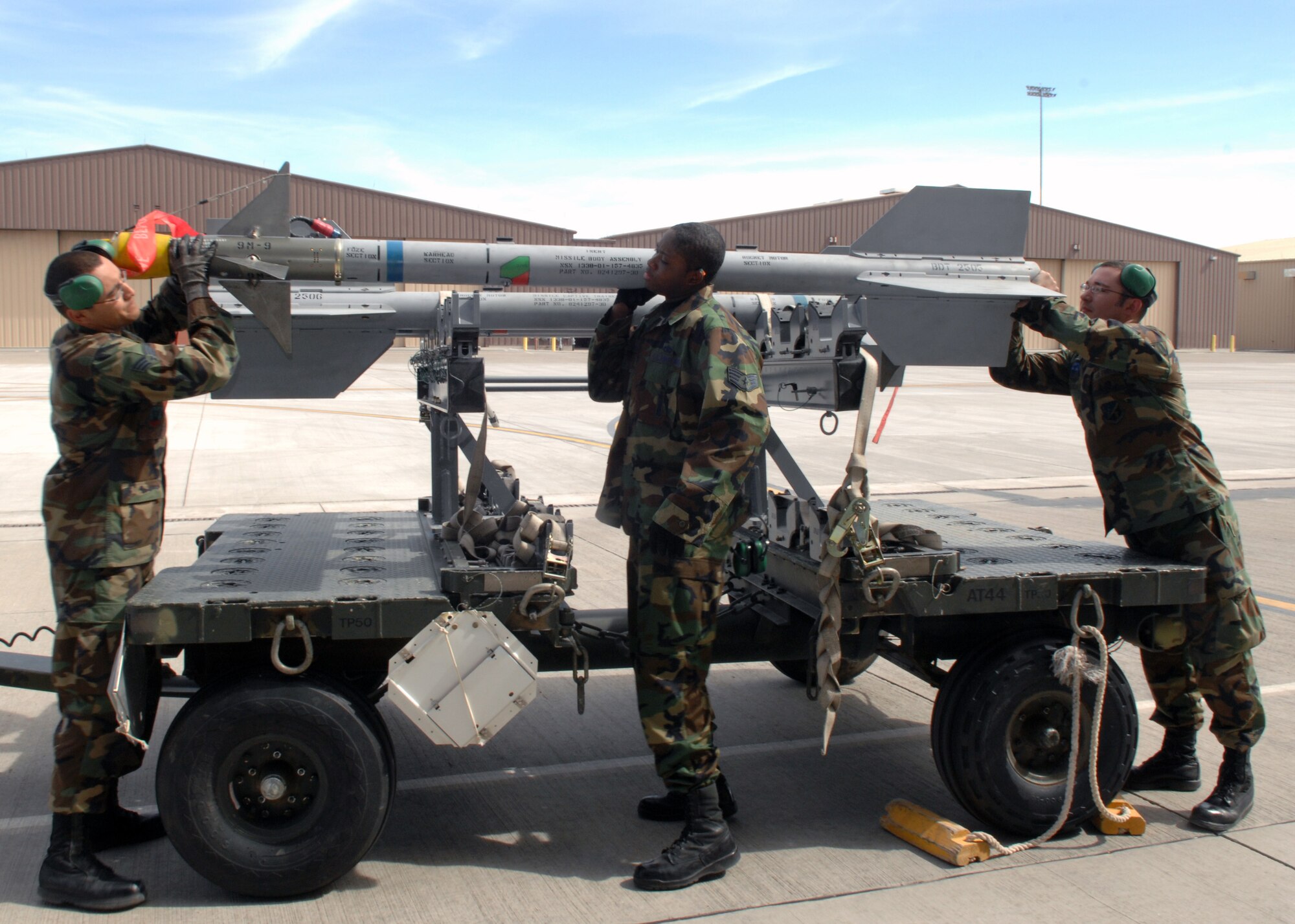 Weapon load crew members from the 49th Aircraft Maintenance Squadron, carry an Aim-9 missile to place inside an F-22A Raptor at Holloman Air Force Base, N.M., Feb. 23. As part of a base-wide exercise, missiles and flares were loaded to prepare aircraft for a mock deployment to Anderson Air Base, Guam. (U.S. Air Force photo/Airman 1st Class Veronica Salgado)