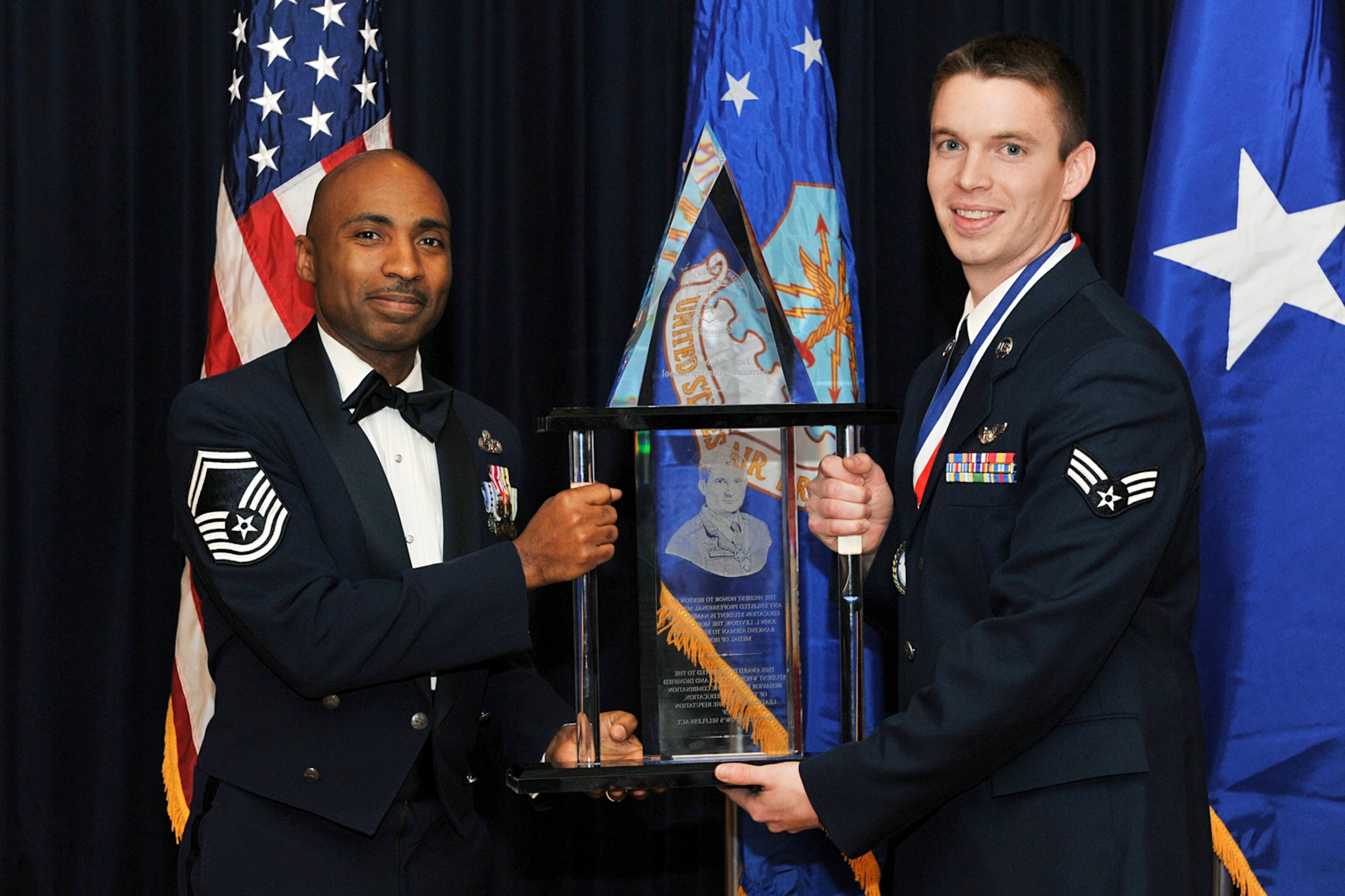 OFFUTT AIR FORCE BASE, Neb. ? Senior Master Sgt. Mervin Dennis, first sergeant for the 97th Intelligence Squadron, and Senior Airman Scott William pose for a photograph after Airman William was presented with the John L. Levitow award for the James M. McCoy Airman Leaership School Class 09- C Feb.12. After four weeks of dedication and hard work, 37 graduates lined up to receive their diplomas.