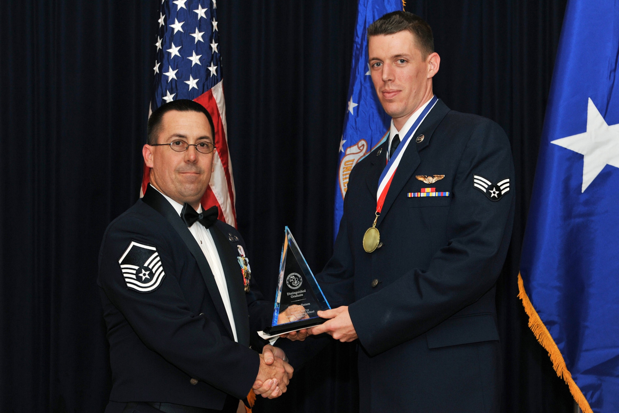 OFFUTT AIR FORCE BASE, Neb. ? Master Sgt. Evan Downey, commandant of the James M. McCoy Airman Leadership School, presents Senior Airman Ryan Dotson, 338th Combat Training Squadron, with his distinguished graduate award for Class 09- C Feb. 12. Through four weeks of dedication and hard work, 37 graduates have enhanced their leadership skills to guide this next generation of airman coming into the Air Force.