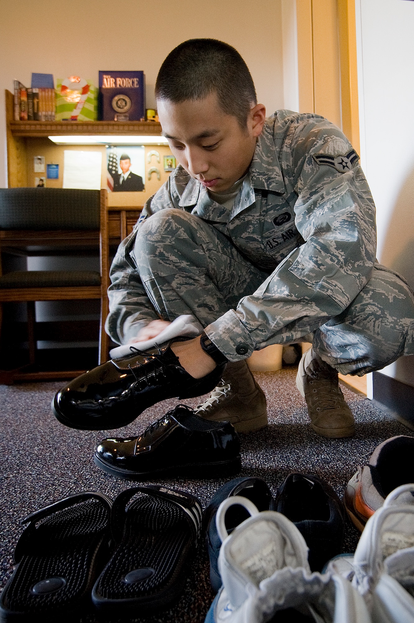 Airman 1st Class Daniel Kim, a technician in the 62nd Force Support Squadron career developement section, shines his shoes as part of his daily cleaning regimen. Airman Kim was recently presented a coin after a wing inspector was amazed with how clean he kept his room. (U.S. Air Force photo/Abner Guzman)