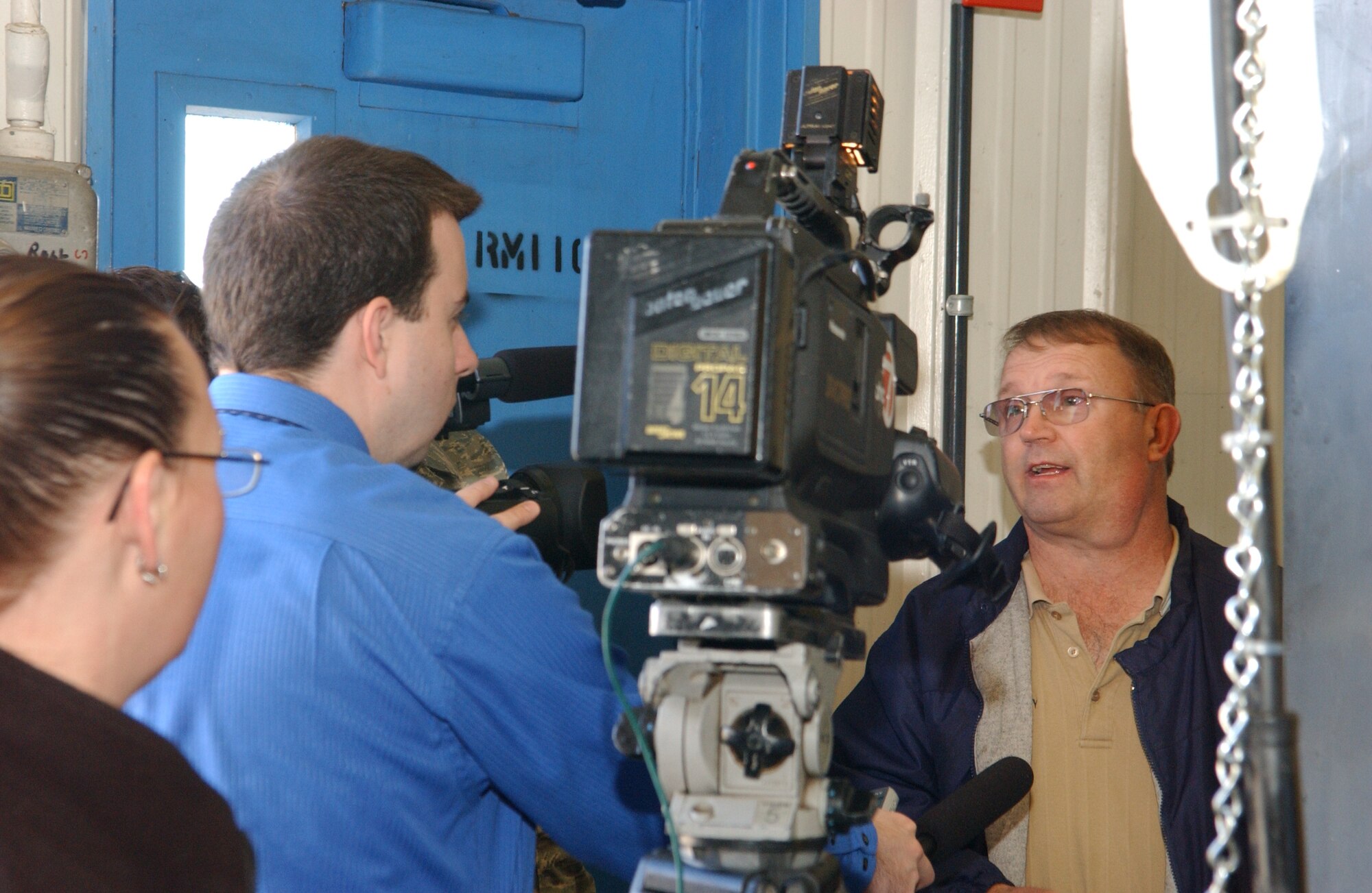 ALTUS AIR FORCE BASE, Okla. – Channel 7 news crew from Lawton, Okla., interviews George Corey, 97th Maintenance Directorate survival equipment supervisor, about the new waste water treatment system. Mr. Corey developed the idea of the environmentally friendly system, which will drastically reduce the amount of exported waste from more than 27,000 pounds to less than 10 pounds annually. The water cleaning system uses biological media to consume the hazardous waste, which in turn creates a reusable supply of cleaning water. The new system will save the 97 AMW more than $47,500 per year. (U.S. Air Force Photo/Airman 1st Class Leandra D. Hernandez)