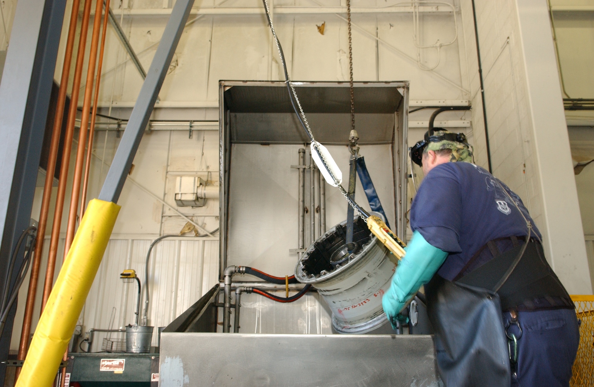 ALTUS AIR FORCE BASE, Okla. – Kent Reitenour, 97th Maintenance Directorate wheel and tire shop mechanic prepares a KC-135 wheel to be cleaned in an automated wheel washer. After the washing process, the hazardous waste material is sent via pipe to a newly implemented environmentally friendly waste water treatment system drastically reducing the amount of exported waste from more than 27,000 pounds to less than 10 pounds annually. The water cleaning system uses bio media to consume the hazardous waste, which in turn creates a reusable supply of cleaning water. The new system will save the 97 AMW more than $47,500 per year.(U.S. Air Force Photo/Airman 1st Class Leandra D. Hernandez) 