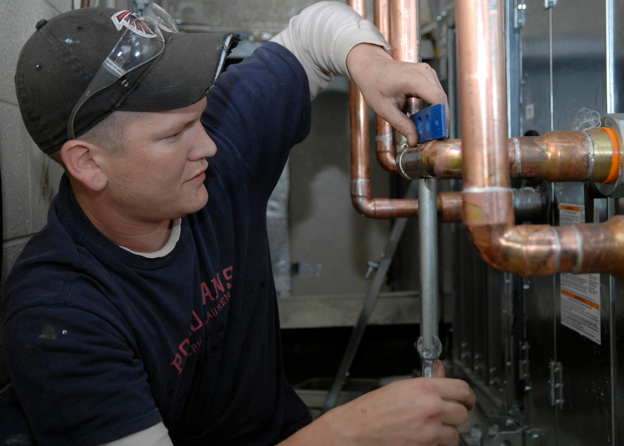 Rob Smith levels the supply and return lines Feb. 18 for part of a heating, ventilation and air conditioning system being installed at Charleston Air Force Base, S.C.. Currently, there are four HVAC installation projects taking place at facilities where outdated, inefficient heating and cooling equipment is being replaced with new, energy-efficient equipment and controls to help the base conserve energy. Mr. Smith is a plumber with a local contractor. (U.S. Air Force photo/Senior Airman Katie Gieratz)