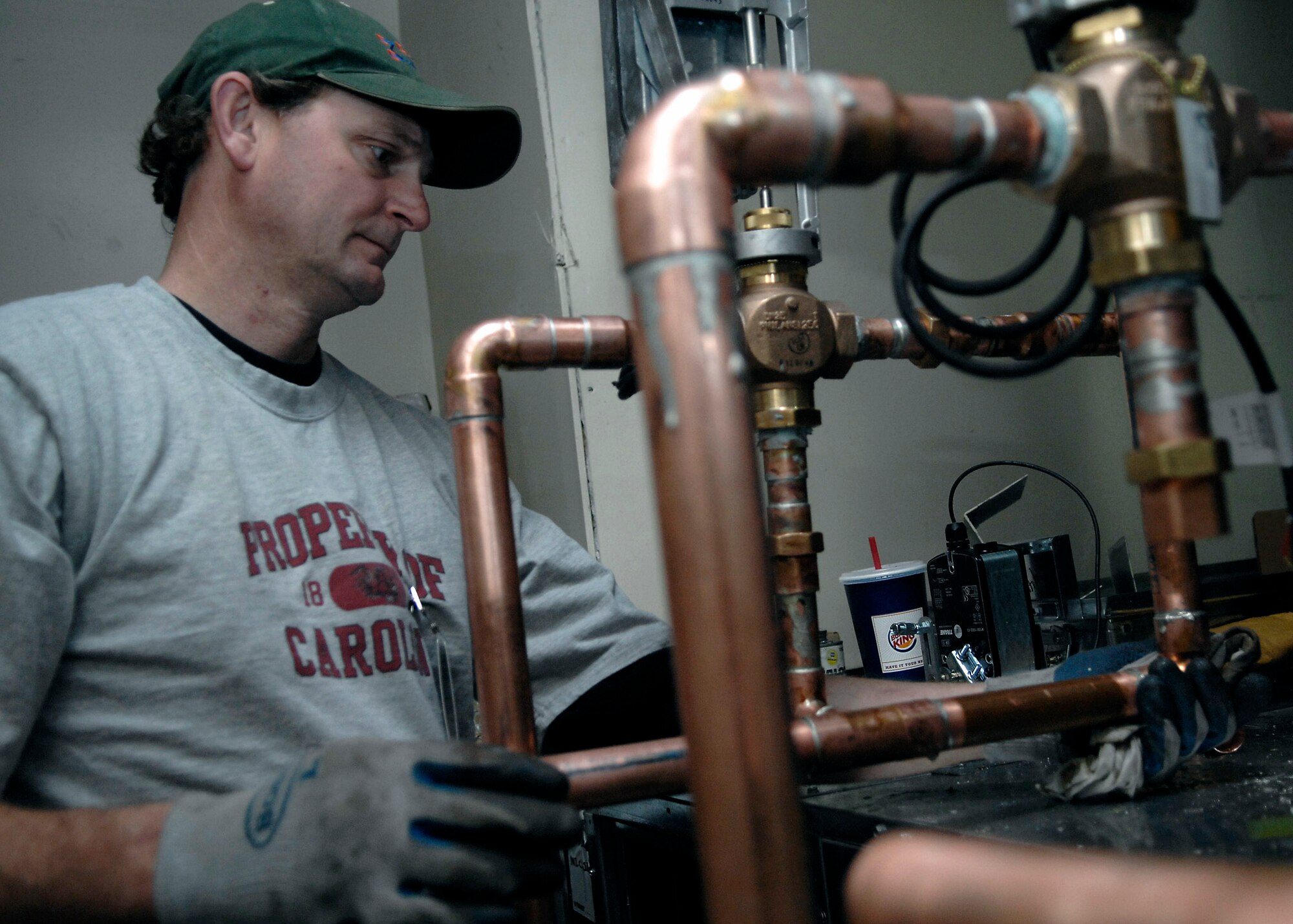 Johnny Radcliffe wipes down the copper pipes Feb. 18 to cool and set the soldering for a heating, ventilation and air conditioning system being installed at Charleston Air Force Base, S.C.  Currently, there are four HVAC installation projects taking place at facilities where outdated, inefficient heating and cooling equipment is being replaced with new, energy-efficient equipment and controls to help the base conserve energy.  Mr. Radcliffe is a foreman for a local plumbing contractor. (U.S. Air Force photo/Senior Airman Katie Gieratz)