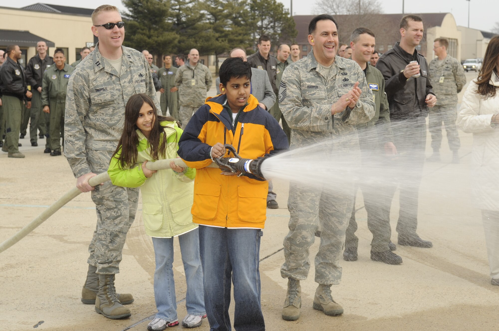 Col. Balan Ayyar, 305th Air Mobility Wing commander, gets hosed down by his children after his fini-flight on a C-17 Feb. 26. After landing, family, friends and McGuire personnel were on the ground to celebrate with him. Colonel Ayyar is scheduled to relinquish command of the 305th AMW March 3, 10 a.m., at Hangar 2201. (U.S. Air Force photo/Carlos Cintron)