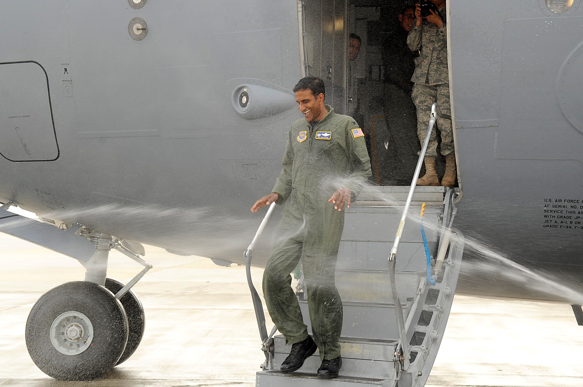 Col. Balan Ayyar, 305th Air Mobility Wing commander, steps off his fini-flight on a C-17 to be hosed down by family members and fellow McGuire leadership Feb. 26. Colonel Ayyar is scheduled to relinquish command of the 305th AMW March 3, 10 a.m., at Hangar 2201. (U.S. Air Force photo/Carlos Cintron) 
