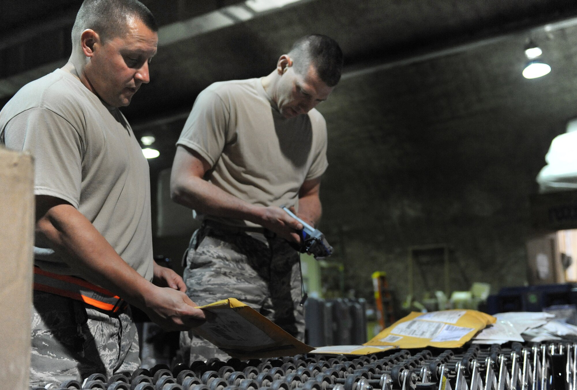Tech. Sgt. Joe Hill assists Staff Sgt. Mark Garcia during the in-checking process from a recent shipment Feb. 17 at Joint Base Balad, Iraq. Sergeant Hill uses an electronic device linked to an inventory system to in-check cargo. Sergeant Hill is the 332nd Expeditionary Logistics Readiness Squadron NCO-in charge of in-bound operations deployed from Scott Ill. He is a native of O'fallon, Ill. Sergeant Garcia is assigned to the 332nd Expeditionary Logistics Readiness Squadron in-bound freight section and deployed from Salt Lake City Guard Base. He is a native of Ogden, Utah. (U.S. Air Force photo/Senior Airman Elizabeth Rissmiller) 
