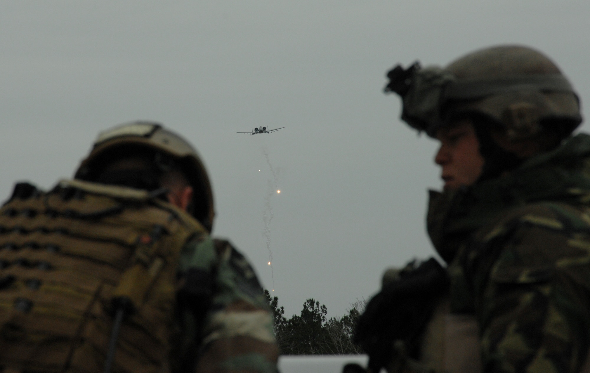 Two Joint Terminal Attack Controllers coordinate a close-air support attack as an A-10C from the 354th Fighter Squadron here approaches to perform moving-target strafe training during Green Flag East, an exercise in Louisiana for flying units that perform air-to-ground combat. (U.S. Air Force photo/Staff Sgt. Jake Richmond)