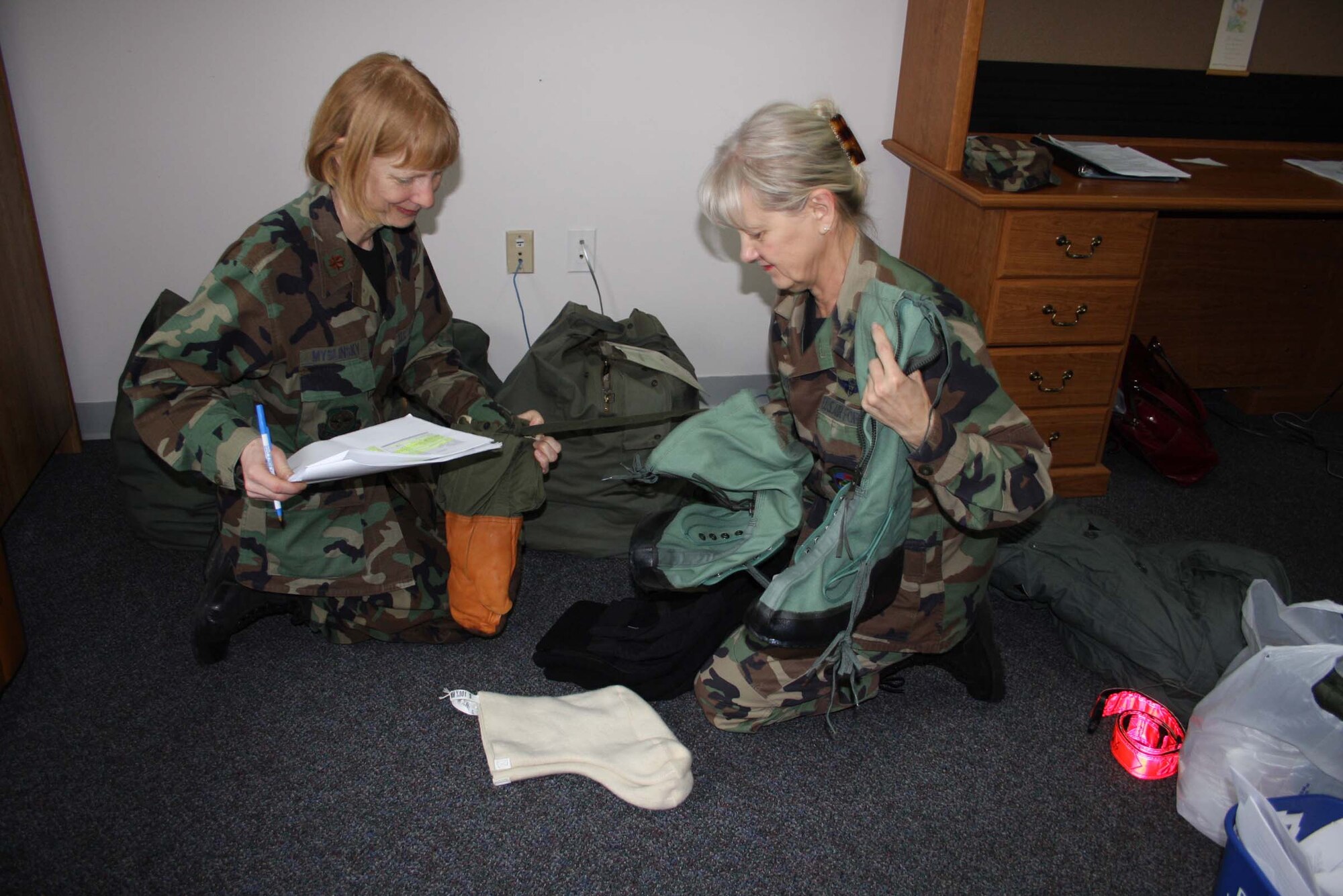 WRIGHT-PATTERSON AFB, Ohio – Col. Karen Nagafuchi and Maj. Margaret Myslinski, both from the 445th Aeromedical Staging Squadron, inventory their cold weather gear in preparation of their Mar. 6 deployment to Bethel, Alaska. The officers will be part of a group of 200 multi-service members from across the nation participating in Operation Arctic Care, a humanitarian mission sponsored by the Innovative Readiness Training Program under the Office of the Assistant Secretary of Defense for Reserve Affairs.  The group will be divided into teams to provide much needed no-cost health care, health education and veterinary services to 11 underserved populations within Alaska’s Yukon/Kuskokwim Delta region. (Air Force photo/Stacy Vaughn)