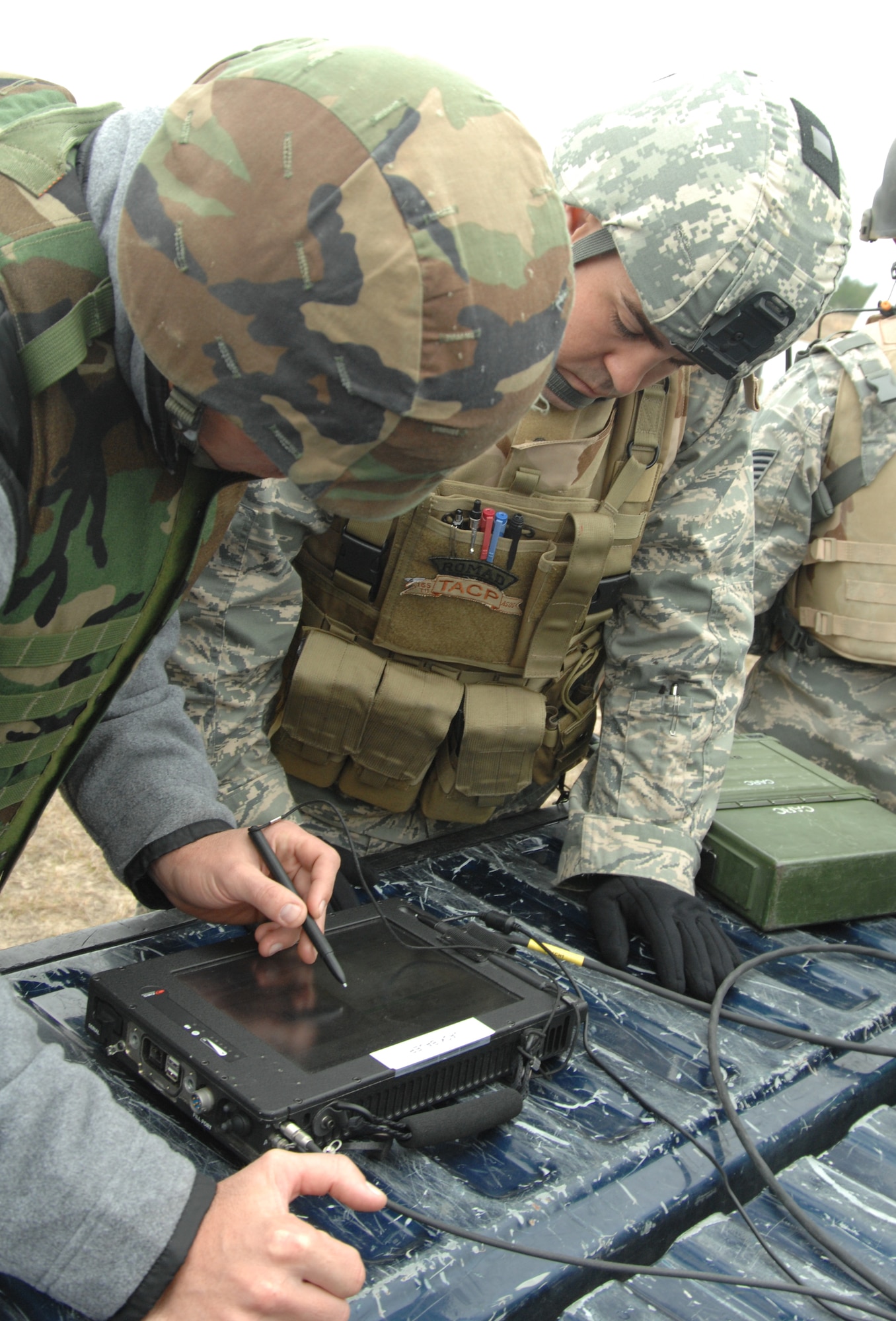 Mr. Timm Finn (left), a contractor specializing in the Tactical Air Control Party, Close Air Support System, shows a Joint Terminal Attack Controller how the digital system is used to relay information to inbound pilots. (U.S. Air Force photo/Staff Sgt. Jake Richmond)