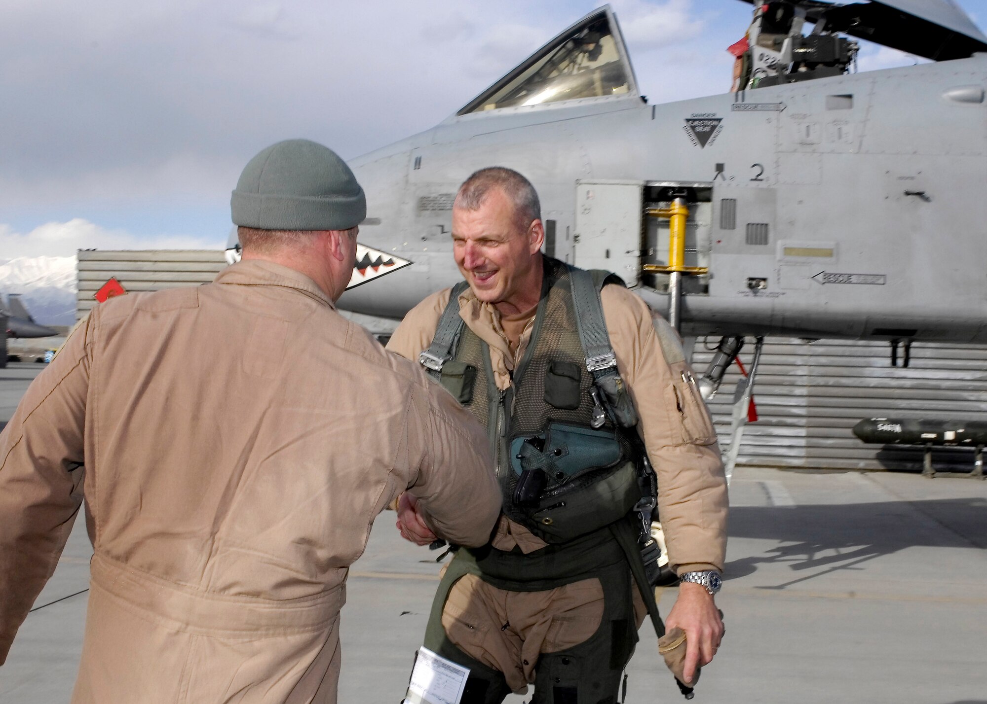 Lt. Col. Sam Milam shakes hands with Col. Raymond Strasburger after the pair completed a mission that logged more than 10,000 combat flight hours for the 75th Expeditionary Fighter Squadron in a single deployment Feb. 24 at Bagram Airfield, Afghanistan. Members of the 75th Expeditionary Fighter Squadron arrived here in September for a four-month deployment, but was extended to six months. Colonel Milam is the 75th EFS commander. Colonel Strasburger is the 455th Expeditionary Operations Group commander. (U.S. Air Force photo/Staff Sgt. Jason Lake) 
