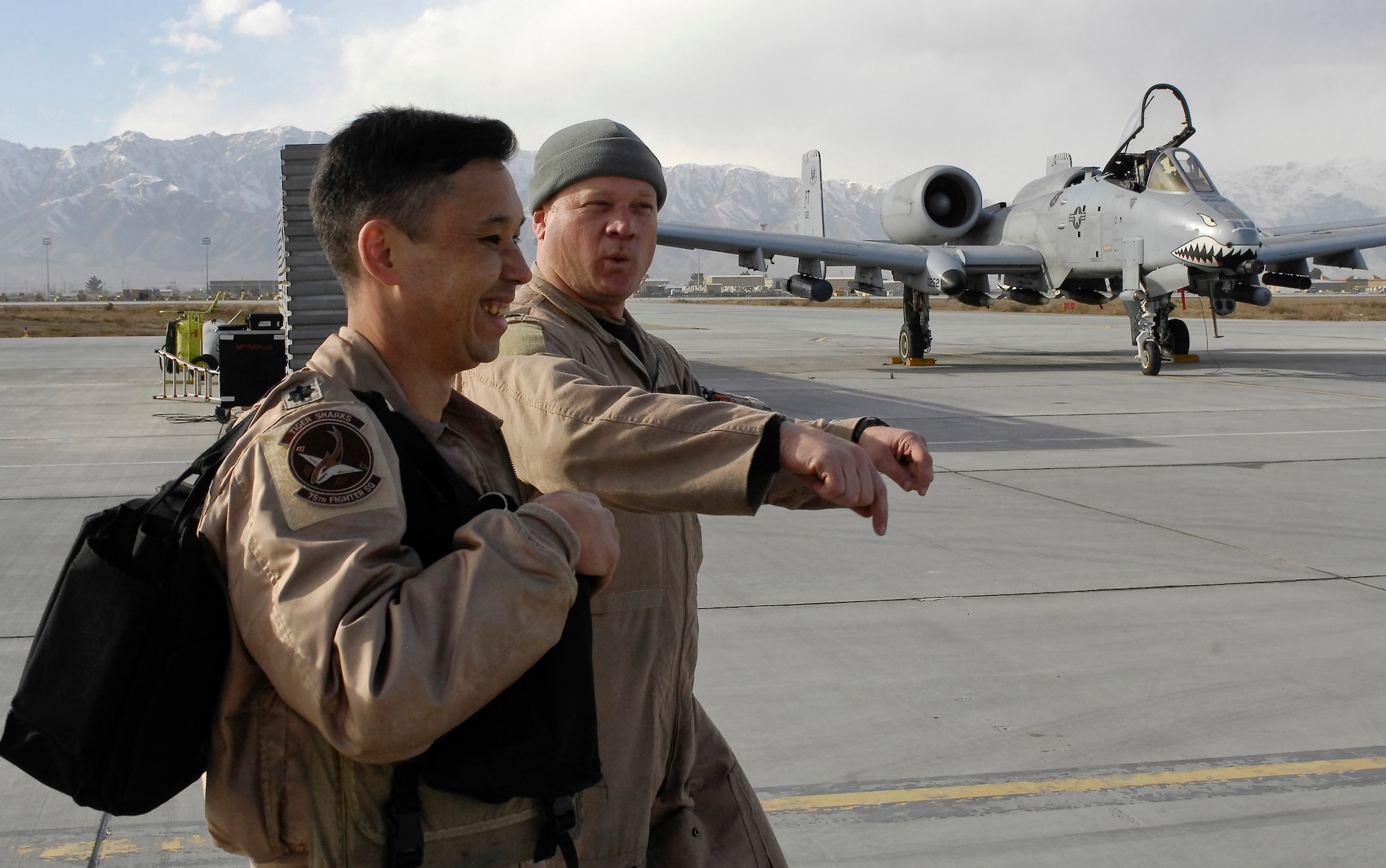 Lt. Col. Richard Piazza walks with Lt. Col. Sam  Milam on their way to congratulate Col. Raymond Strasburger who flew on the unit's 10,000th combat flight hour mission Thunderbolt II after logging his unit's 10,000th combat flight during a single deployment rotation Feb. 24 at Bagram Airfield, Afghanistan. Members of the 75th Expeditionary Fighter Squadron arrived here in September for a four-month deployment, but was extended to six months. Colonel Piazza is the 75th EFS director of operations, and Colonel Milam is the 75th EFS commander. Colonel Strasburger is the 455th Expeditionary Operations Group commander. (U.S. Air Force photo/Staff Sgt. Jason Lake) 
