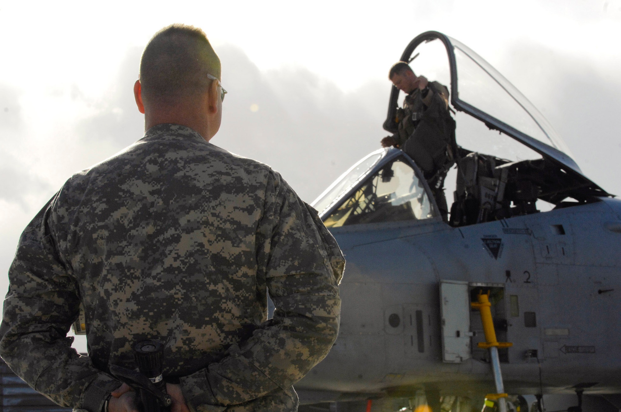 Army Lt. Col. George Chizmar hides a fire hose behind his back as Lt. Col. Sam Milam prepares to disembark an A-10 Thunderbolt II after logging his unit's 10,000th combat flight during a single deployment rotation Feb. 24 at Bagram Airfield, Afghanistan. Members of the 75th EFS arrived here in September for a four-month deployment, but was extended to six months. Colonel Chizmar is the ground liason officer, and Colonel Milam is the 75th Expeditionary Fighter Squadron commander. (U.S. Air Force photo/Staff Sgt. Jason Lake) 

