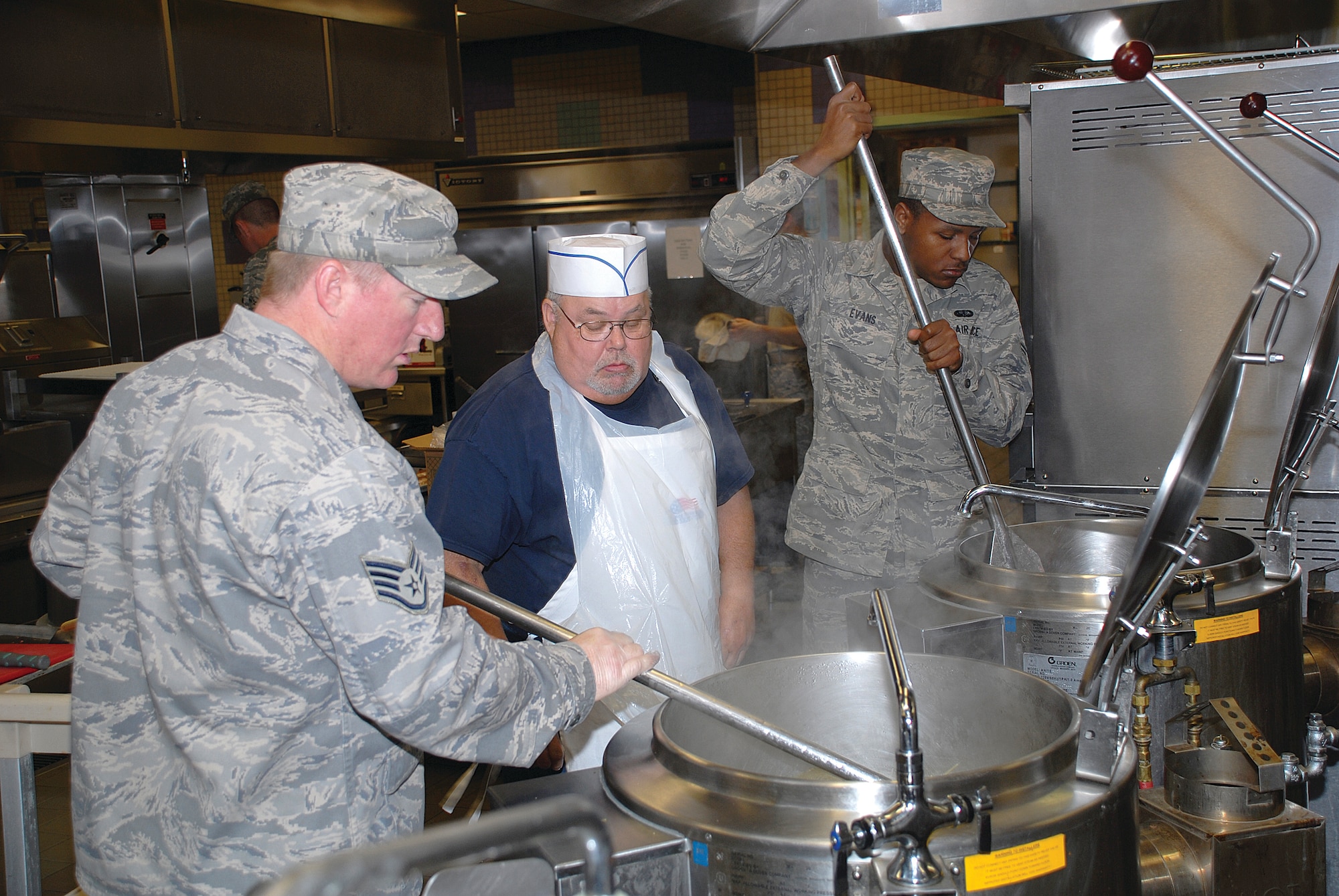 Staff Sgt. Corey Butler and James Westmoreland, 56th Services Squadron Food Service shift leaders, discuss the amount of spaghetti to be added to a pot of boiling water while cooking lunch at the Ray V. Hensman Dining Facility. (U.S. Air Force photo/ Airman 1st Class Traci Forte)