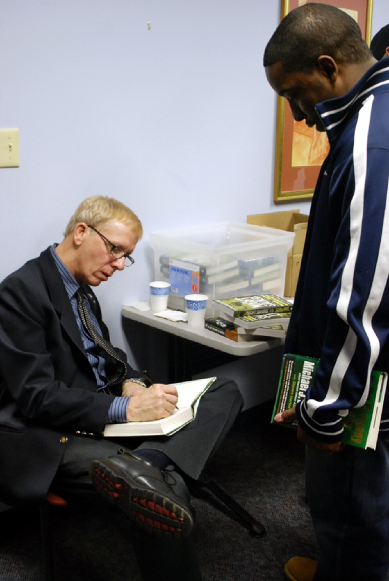 Left, Steven Hartov, author of “In the Company of Heroes,” signs a book for Senior Airman Maurice Johnson, 421st Combat Training Squadron instructor, at the library Feb. 25. The author visited McGuire to discuss his writing career as well as the story of Michael Durant, the pilot of Black Hawk Down helicopter Super Six Four that crashed during a combat operation in Mogadishu, Somalia, in 1993. Attendees had the chance for a question and answer session with Mr. Hartov and to get their books signed at the end. The McGuire Library has special events coming up in March as well, including “Decorating a user-friendly home” with a professional interior designer, March 25 at 6:30 p.m., and “Women Entrepreneurs” March 26 at 6:30 p.m. For more information or to sign up (by March 20), call (609) 754-2079. (U.S. Air Force photo/Senior Airman Bekah Phy)  
