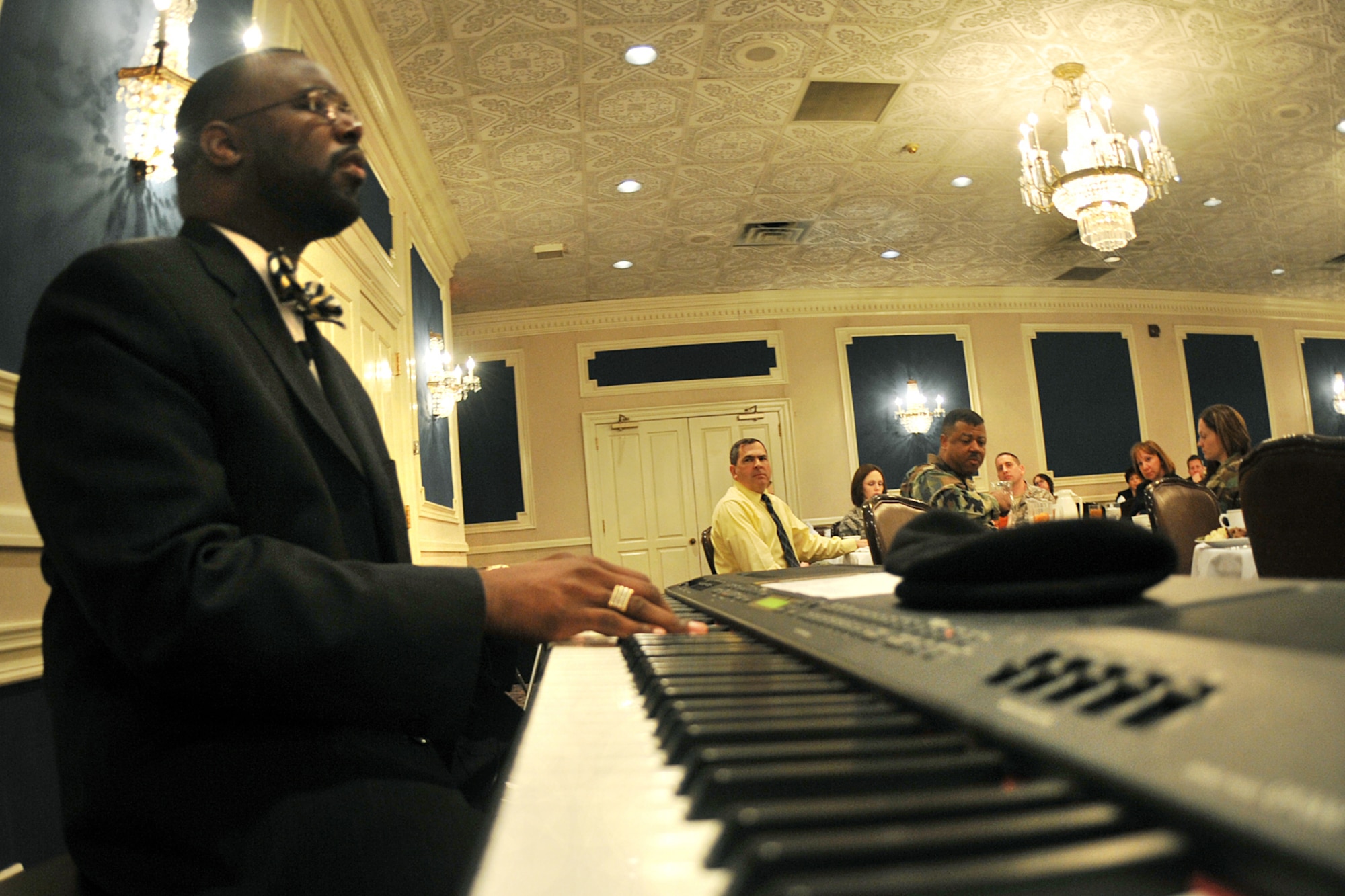 OFFUTT AIR FORCE BASE, Neb., -- Rev. Frederick McCullough, pastor of St. John Christian Methodist Episcopal church, plays the piano and sings a song of inspiration during the National Prayer Luncheon held at the Patriot Club Feb. 24. Throughout this luncheon, many of Offutt?s personnel representing different faiths and backgrounds came together to pray for warriors fighting for our nation and our families. 