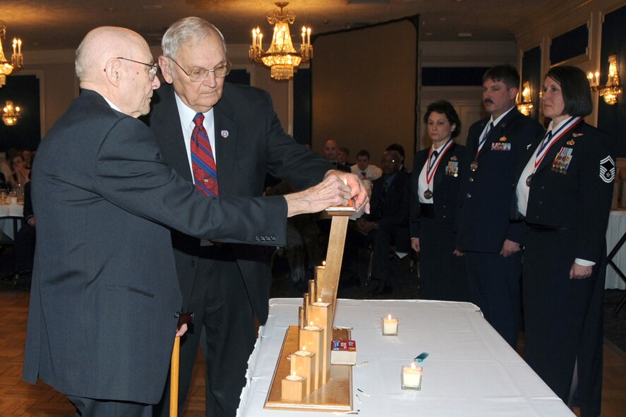OFFUTT AIR FORCE BASE, Neb.-- Retired Chief Master Sgt. William T. Whitney, and retired Chief Master Sgt. Theodore Brewer,  light the final traditional candle symbolizing the promotion to the top one percent of the enlisted force during the Chief's Group Annual Recognition Ceremony at the Patriot Club Feb. 20. U.S. Air Force Photo by Jeff Gates