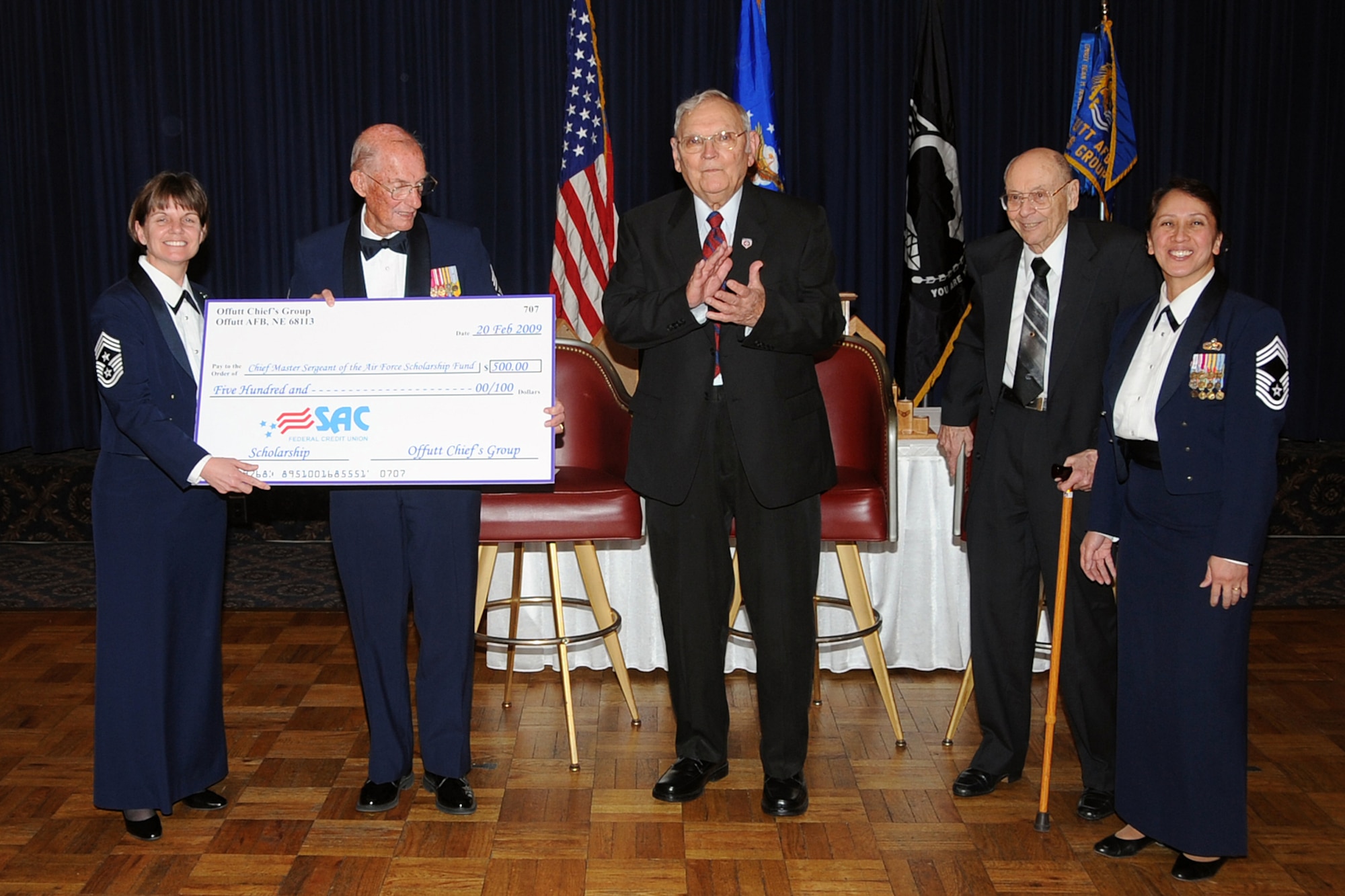 OFFUTT AIR FORCE BASE, Neb.-- 55th Wing Command Chief Master Sgt. Lisa Sirois, presents a check for $500.00 from the Chiefs Goup to retired Chief Master Sgt. of the Air Force James M. McCoy for the Chief Master Sgt. of the Air Force Scholarship Fund. Alongside him are the guest speakers, retired Chief Master Sgt. William T. Whitney and retired Chief Master Sgt. Theodore Brewer. The Offutt Chief's Group Annual Recognition Ceremony was held at the Patriot Club Feb. 20. U.S. Air Force Photo by Jeff Gates
