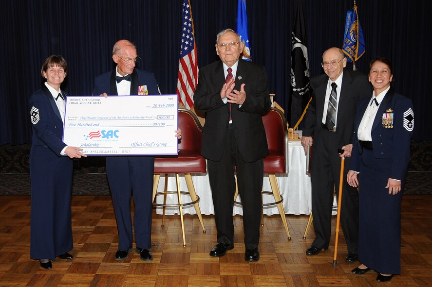 OFFUTT AIR FORCE BASE, Neb.-- 55th Wing Command Chief Master Sgt. Lisa Sirois, presents a check for $500.00 from the Chiefs Goup to retired Chief Master Sgt. of the Air Force James M. McCoy for the Chief Master Sgt. of the Air Force Scholarship Fund. Alongside him are the guest speakers, retired Chief Master Sgt. William T. Whitney and retired Chief Master Sgt. Theodore Brewer. The Offutt Chief's Group Annual Recognition Ceremony was held at the Patriot Club Feb. 20. U.S. Air Force Photo by Jeff Gates