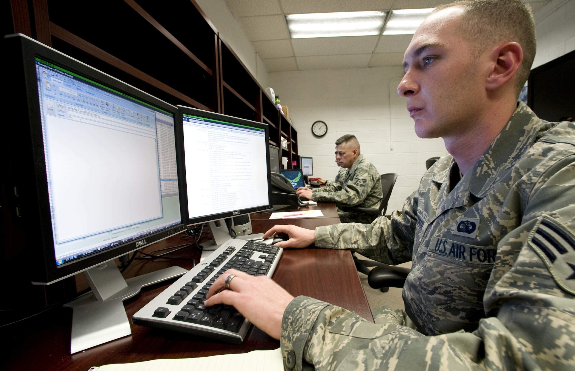 Senior Airman Kyle Stackman (front) and Tech. Sgt. James Thoni with the Information Protection Operations office at Nellis Air Force Base, Nev., monitor the base's computer network to keep it secure.  Airman Stackman is an information protection operations journeyman with the 99th Communication Squadron and Sergeant Thoni is an information protection operations technician on temporary duty to Nellis from the 28th Communications Squadron at Ellsworth AFB, S.D.  (U.S. Air Force photo/Master Sgt. Jack Braden)