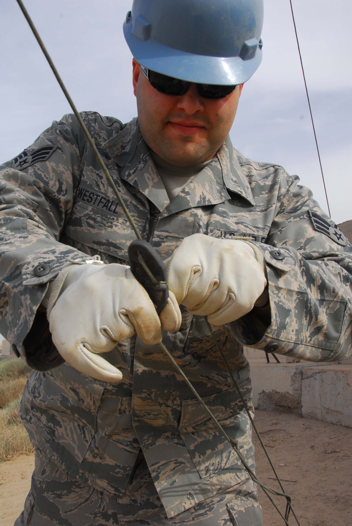 SOUTHWEST ASIA -- Senior Airman Stephon Westfall, 386th Expeditionary Communications Squadron, tightens the one of nine guide wires to steady the Collapsible Tube Mast telescoping antenna mast at an air base in Southwest Asia, Feb. 26. When pulled tightly, the nine guide wires will hold the antenna steady and not allow it to move during a wind or sand storm. Airman Westfall is currently deployed from the 141st Air Refueling Wing, an Air National Guard unit, at Fairchild Air Force Base, Wash., and is originally from Spokane, Wash. (U.S. Air Force photo/ Senior Airman Courtney Richardson)