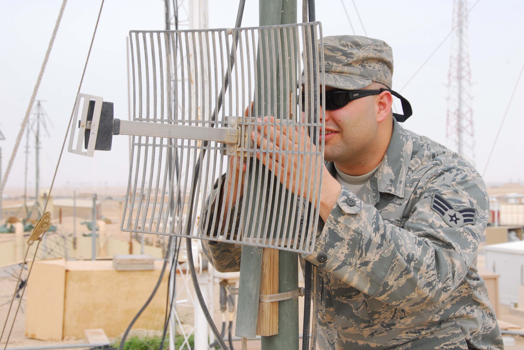 SOUTHWEST ASIA -- Senior Airman Stephon Westfall, 386th Expeditionary Communications Squadron, aligns a Line of Sight antenna at an air base in Southwest Asia, Feb. 26. After a sand or wind storm, the LOS antenna must be realigned to maintain an open connection with the receiver. Airman Westfall is currently deployed from the 141st Air Refueling Wing, an Air National Guard unit, at Fairchild Air Force Base, Wash., and is originally from Spokane, Wash. (U.S. Air Force photo/ Senior Airman Courtney Richardson)