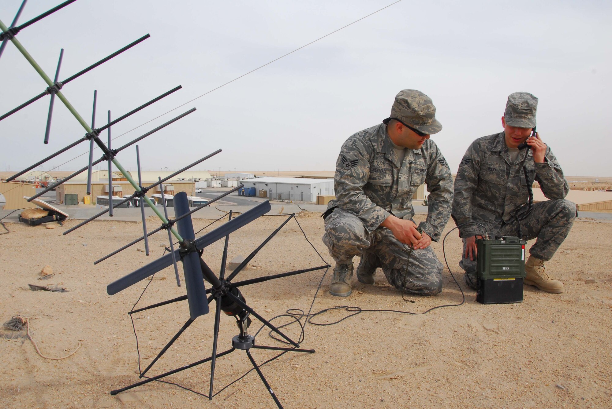 SOUTHWEST ASIA -- Senior Airman Stephon Westfall and Senior Airman Kevin Wolff, 386th Expeditionary Communications Squadron, perform a radio check on a PRC-117 at an air base in Southwest Asia, Feb. 26. The satellite communication antenna and the PRC-117 must be checked periodically to ensure that the equipment is working properly and to assess for damage. Airman Westfall and Airman Wolff are both currently deployed from the 141st Air Refueling Wing, an Air National Guard unit, at Fairchild Air Force Base, Wash., and are originally from Spokane, Wash. (U.S. Air Force photo/ Senior Airman Courtney Richardson)