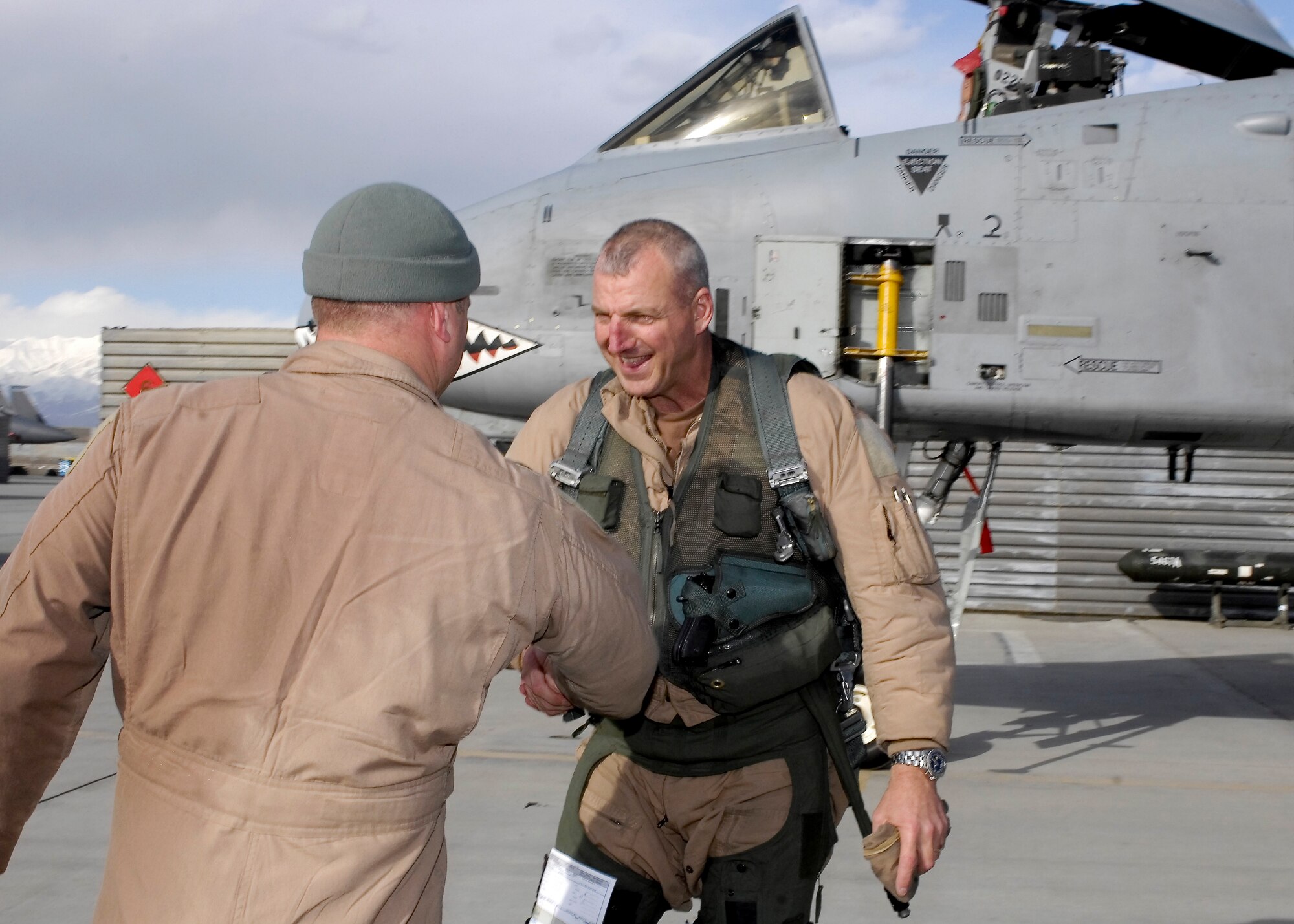 Lt. Col. Sam "Spam" Milam, 75th Expeditionary Fighter Squadron commander, shakes hands with Col. Raymond "Donk" Strasburger, 455th Expeditionary Operations Group commander, shortly after the pair completed a mission that logged more than 10,000 combat flight hours for the 75th EFS in a single deployment to Bagram Air Field, Afghanistan. This was the first time a squadron deployed here reached 10,000 combat hours. The 75th EFS arrived here from Moody Air Force Base, Ga., in September for a four-month deployment, but was extended to six months. The A-10 Thunderbolt II was the first tactical fighter aircraft to deploy here in 2002.  