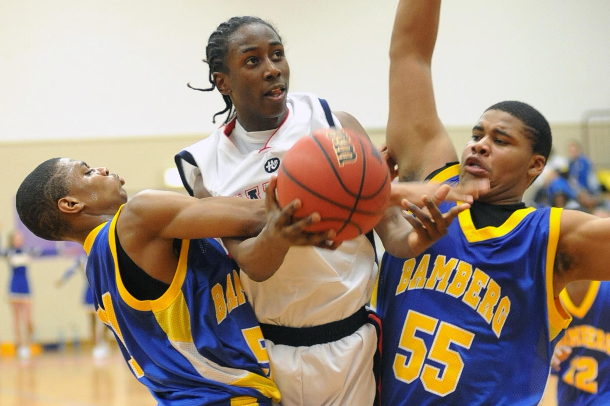 Aviano's Jamal Tuck draws a fouls as he drives between Bamberg's Joshua Robinson, left, and Cortez Lindsey. Aviano beat the Barons 85-59 to win the Division II championship at the DODDS-Europe basketball finals in Mannheim, Germany, Saturday night. (Photo by Michael Abrams. Used with permission from Stars and Stripes. ? 2009 Stars and Stripes)