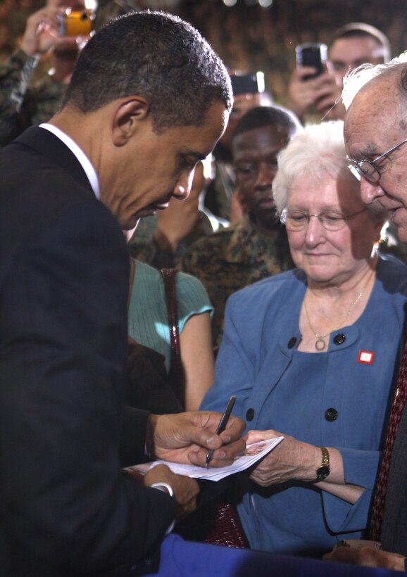 President Barack Obama signs a piece of paper for a civilian after talking to troops and civilians during his visit to Camp Lejeune, N.C., Feb. 27, 2009. Obama was on Camp Lejeune to discuss current policies and an exit strategy from Iraq.
