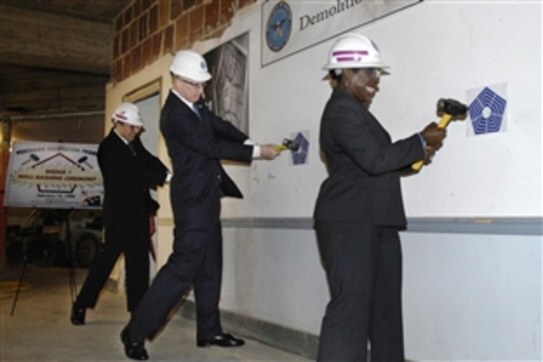 From left: Albert C. "Clai" Ellett, acting director of Washington Headquarters Services, Deputy Secretary of Defense William Lynn, and Eileen Roberson, administrative  assistant to the Undersecretary of the Navy, hit the wall with sledgehammers during a demolition ceremony to commemorate the beginning of the renovation of Wedge 5 of the Pentagon, Feb. 27, 2009.  
