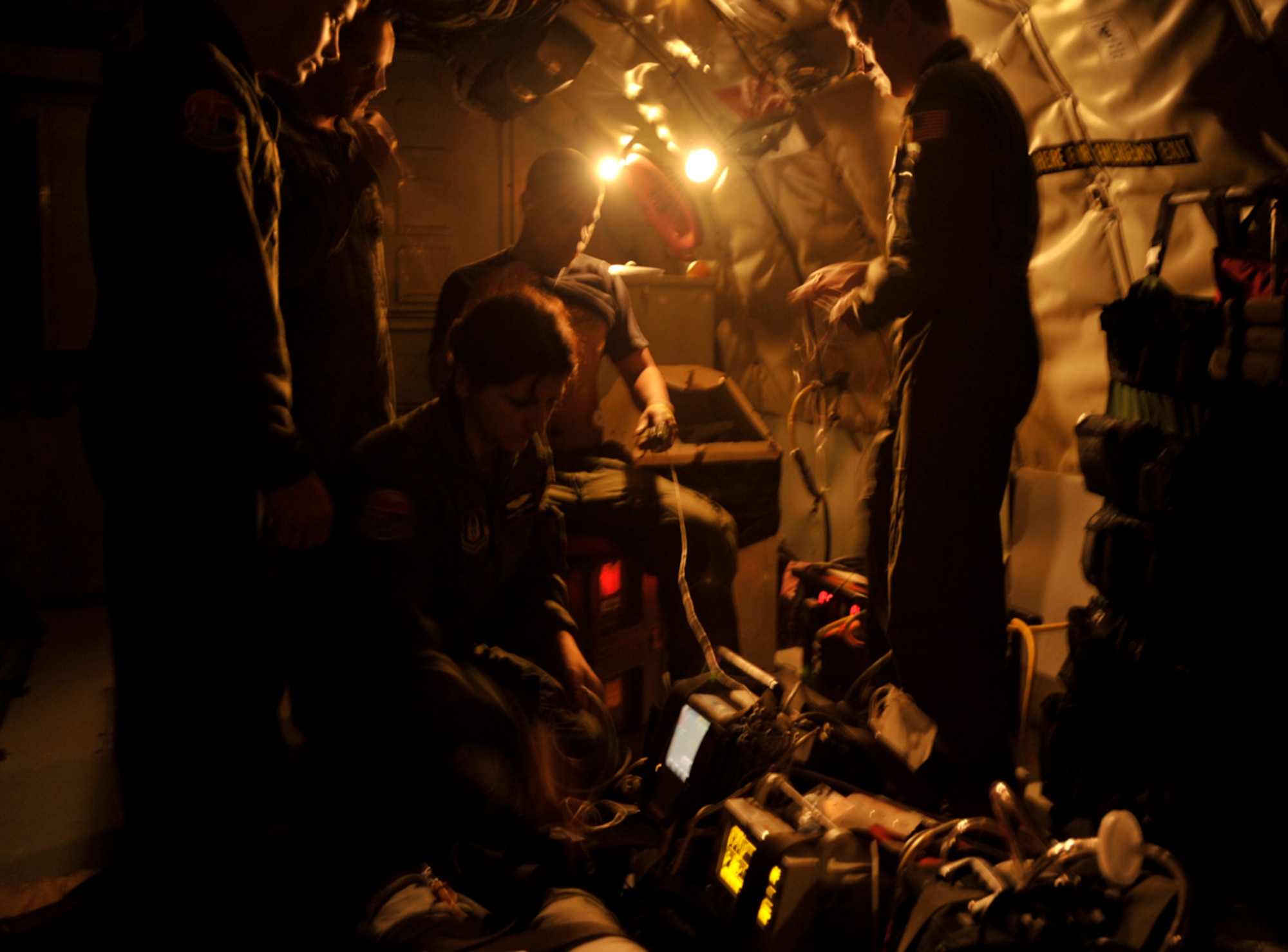 Aeromedical Evacuation Airmen work within the dark confines of a KC-135 Stratotanker flown by members of the 931st Air Refueling Group during a training mission. Air Force officials recently tested a modification that provide more electrical outlets on KC-135s for medical equipment. (U.S. Air Force photo/Tech. Sgt. Jason Schaap) 