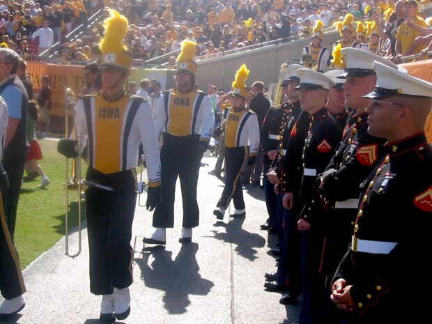 Marines from Marine Corps Southern Command prepare to take the field as the University of Iowa band takes its postion. The Marine Corps honored War on Terrorism veterans and alumni from the representative univeristies at halftime of the Outback Bowl which featured the universities of Iowa and South Carolina.