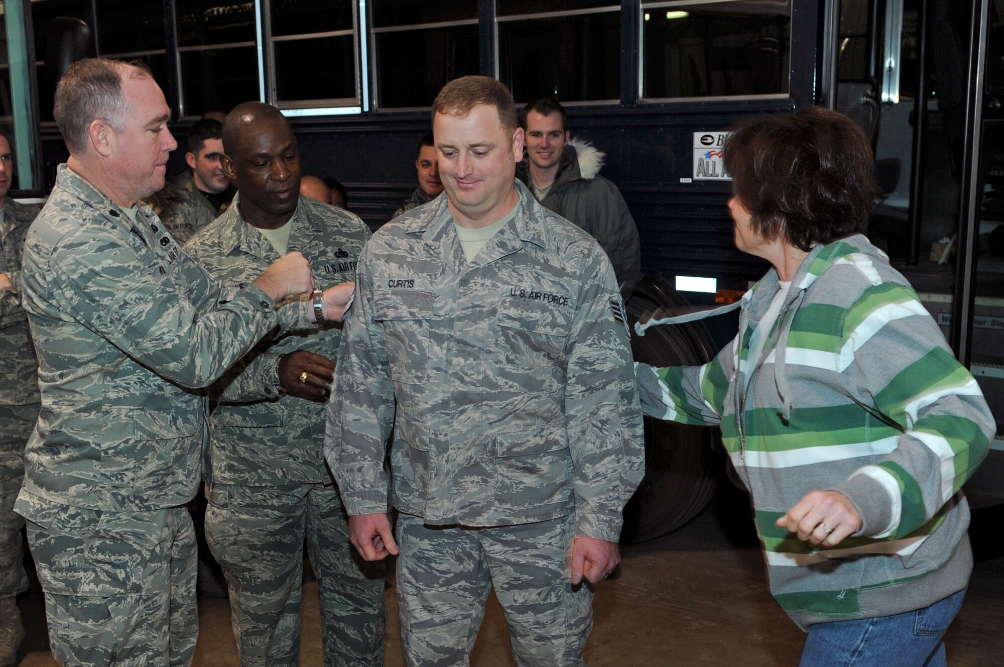 (From left) Lt. Col. James Koontz, 28th Logistics Readiness Squadron commander, Chief Master Sgt. Clifton Cole, 28th Bomb Wing command chief, and Amy Curtis pin on technical sergeant stripes on Staff Sgt. Joseph Curtis, 28th Logistics Readiness Squadron logistics planner, here, Jan. 2. Sergeant Curtis was immediately promoted to technical sergeant through the Stripes for Exceptional Performers program. (U.S. Air Force photo/Senior Airman Marc I. Lane)