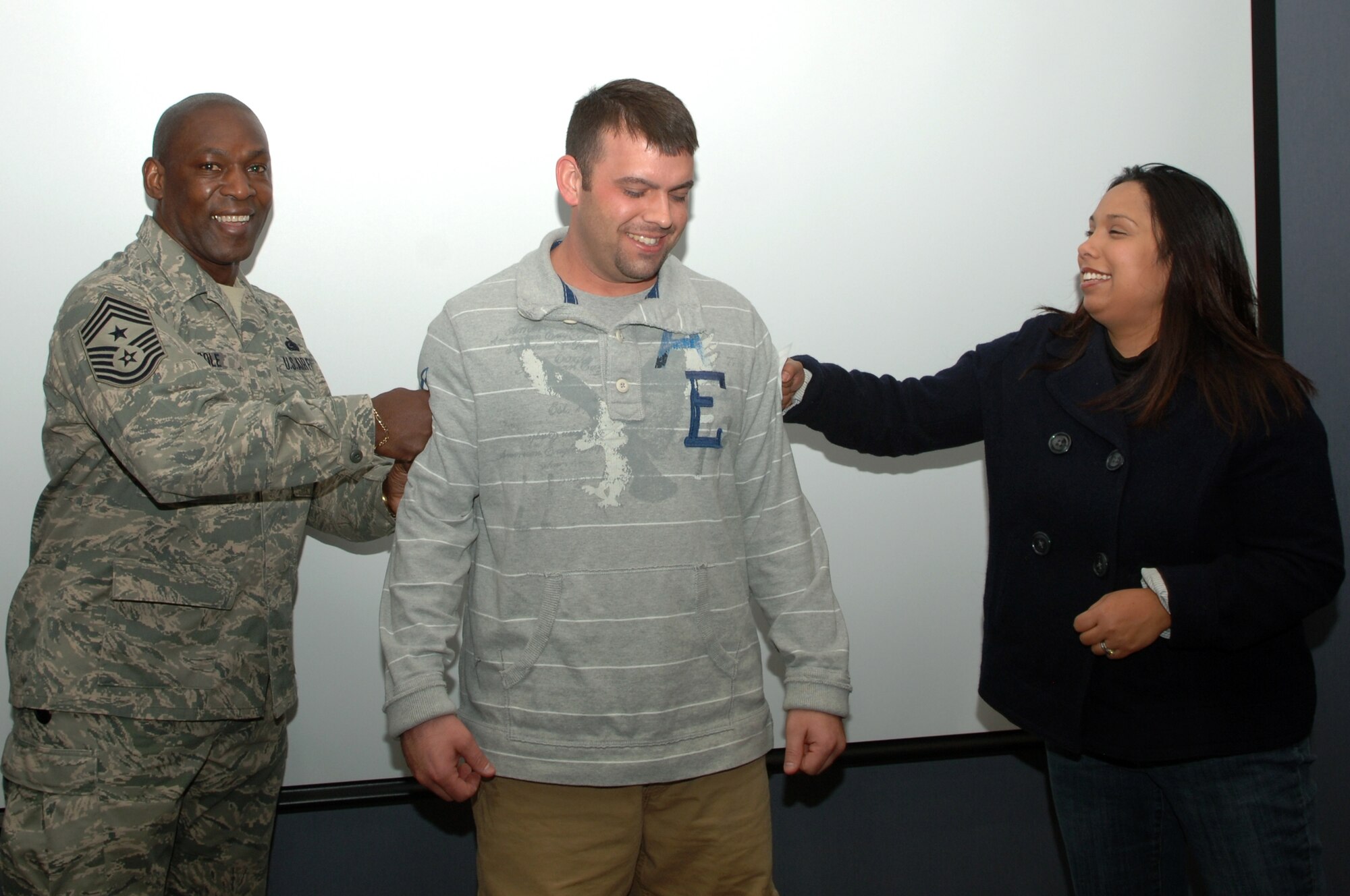 (Center) Staff Sgt. John Hertel, 28th Maintenance Operations Squadron information management manager, is promoted to the rank of technical sergeant through the Stripes for Exceptional Performers program, Jan. 2. Chief Master Sgt. Clifton Cole, 28th Bomb Wing command chief, and Sergeant Hertel’s wife, Susannah, tacked on Sergeant Hertel’s new stripes. (U.S. Air Force photo/Senior Airman Kasey Zickmund)
