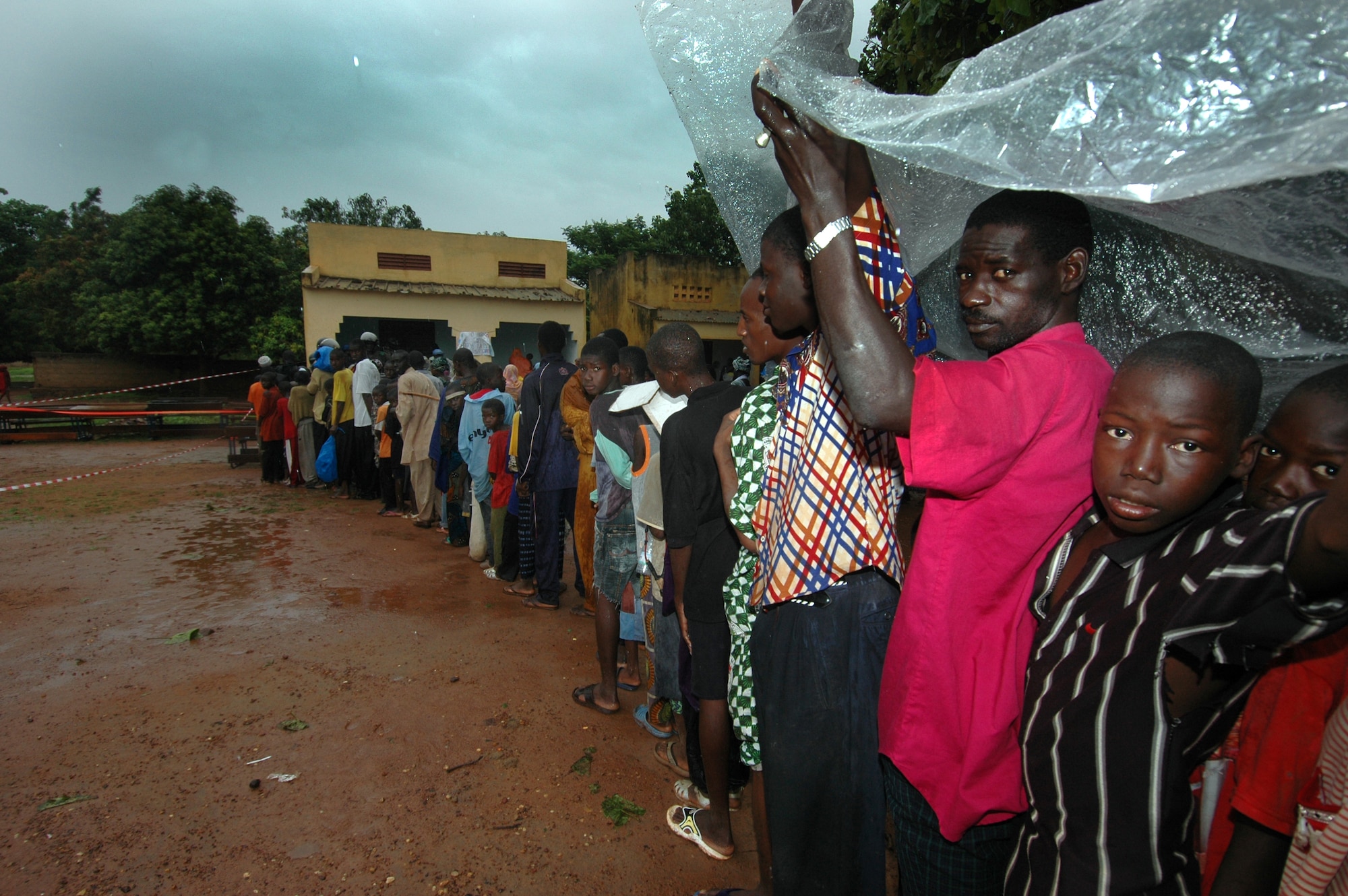 Hundreds of Malians wait in the rain to be seen by doctors during MEDFLAG 08, July 22, 2008. While deployed in support of MEDFLAG 08, medical personnel traveled to four villages near Bamako to provide free clinics for the local population. (U.S. Air Force photo/Senior Airman Justin Weaver)