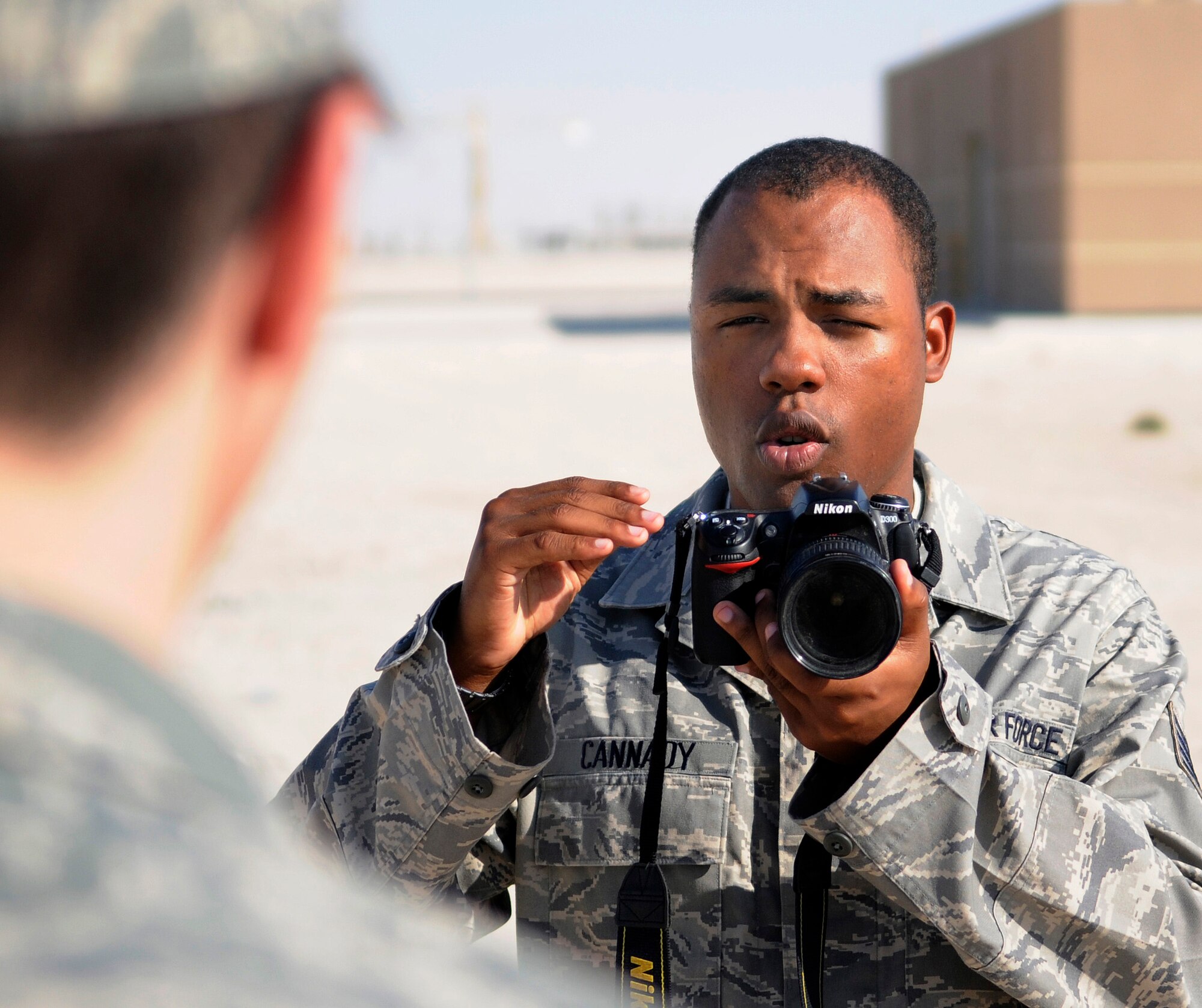 Staff Sgt. Darnell T. Cannady, a photographer assigned to the public affairs office of the 379th Air Expeditionary Wing, sets up a photo, Jan. 1, 2009, at an undisclosed air base in Southwest Asia.  The photographers of the public affairs office are charged with documenting the 379 AEW's efforts in the global war on terror.  They visually tell the Air Force story through photos of airmen performing the mission day after day, through the myriad of jobs that are accomplished on base.  Sergeant Cannady is a native of New Carrollton, Md., and deployed from Kadena Air Base, Japan, in support of Operations Iraqi and Enduring Freedom and Joint Task Force-Horn of Africa.  (U.S. Air Force photo by Tech. Sgt. Michael Boquette/Released)
