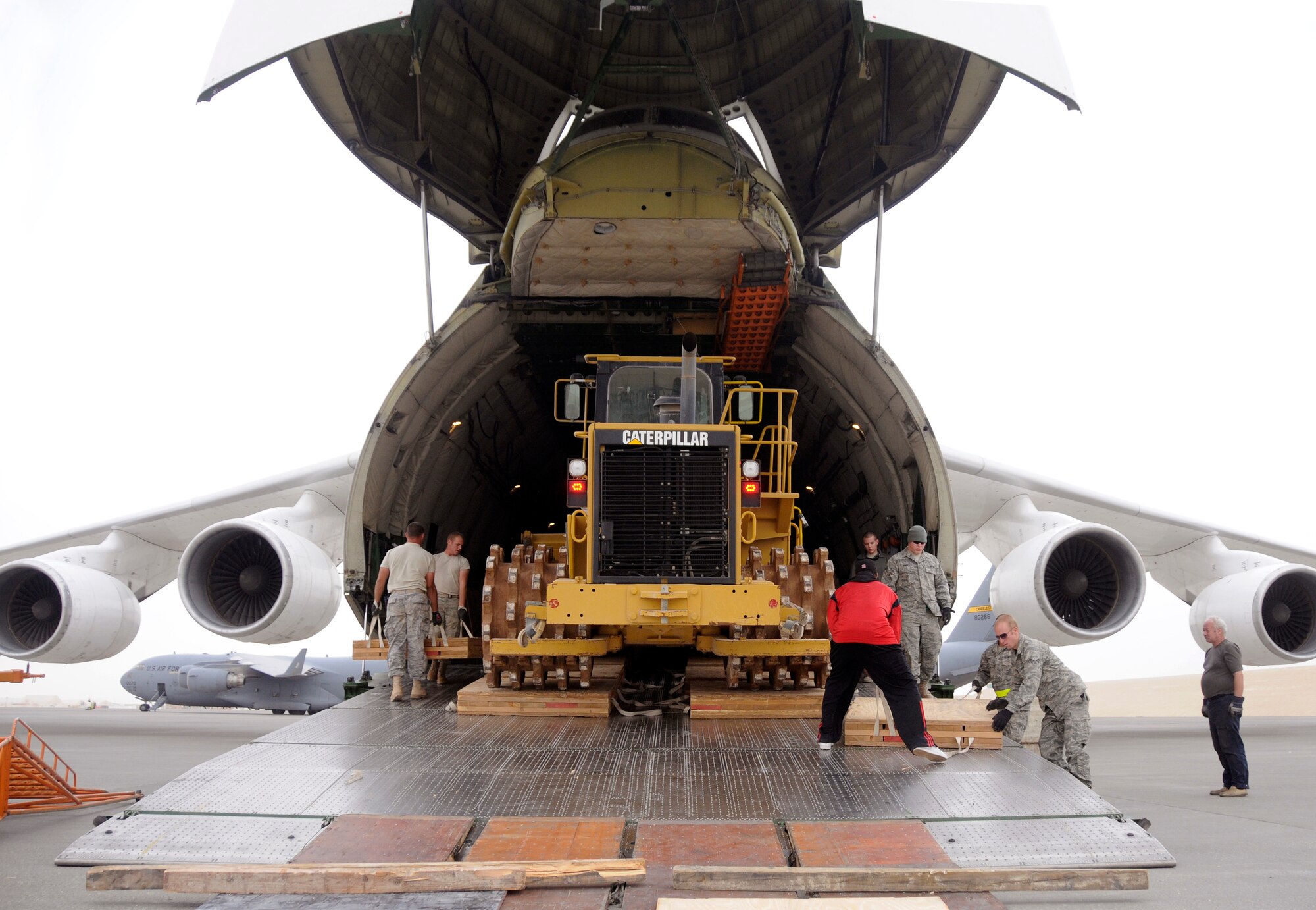 Members of the 1st Expeditionary Red Horse Group load a heavy equipment earth compacter onto a Russian Antonov 124-100 heavy lift cargo aircraft Jan. 2, 2009, at an undisclosed air base in Southwest Asia.  All members are deployed in support of Operations Iraqi and Enduring Freedom and Joint Task Force-Horn of Africa. (U.S. Air Force photo by Staff Sgt. Darnell T. Cannady/Released)