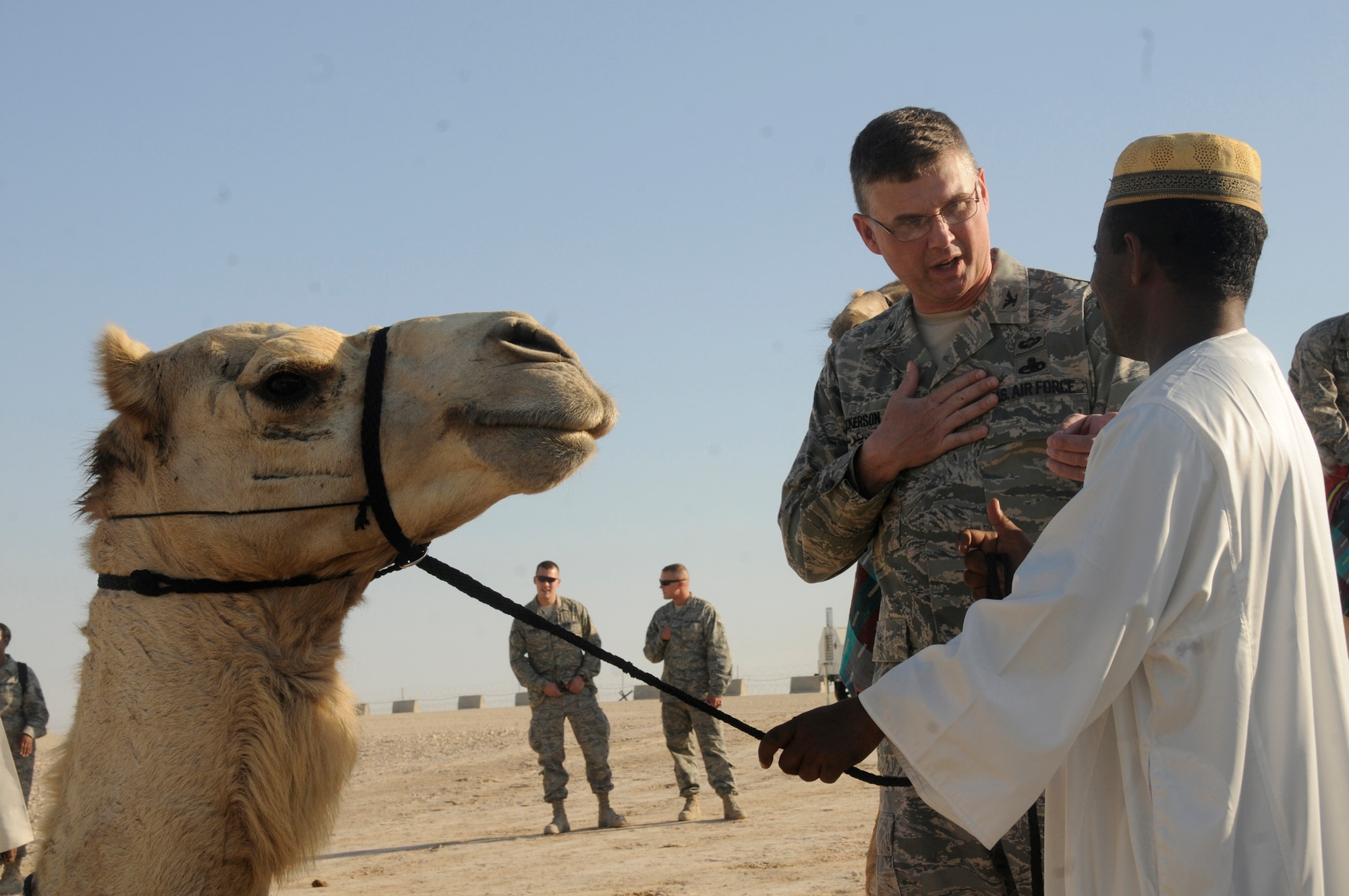 Col. Donald Dickerson, 379th Air Expeditionary Wing Host Nation Coordination Cell director, discusses the camels with a local national at the Arabian Night event Dec. 23, 2008, at an udisclosed air base in Southwest Asia. The HNCC acts as liaison between the U.S. Armed Forces and the host nation. Colonel Dickerson is a native of Roanoke, Va., and is deployed from Travis Air Force Base, Calif. (U.S. Air Force photo by Staff Sgt. Darnell T. Cannady)